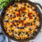 enchilada skillet with cheese, ground beef and olives in cast iron skillet