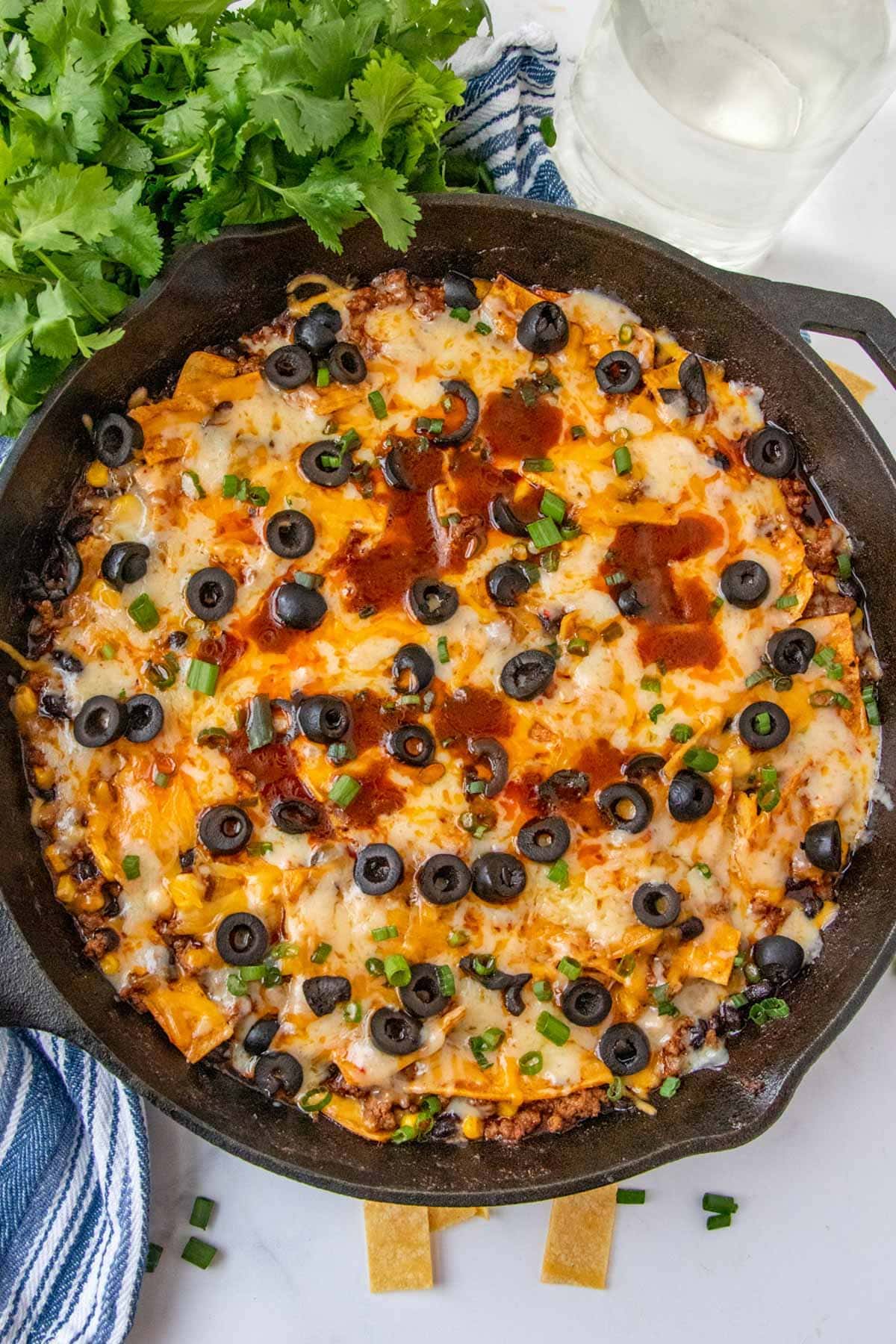 cast iron skillet, ground beef, enchilada sauce, olives, cheese, green onions