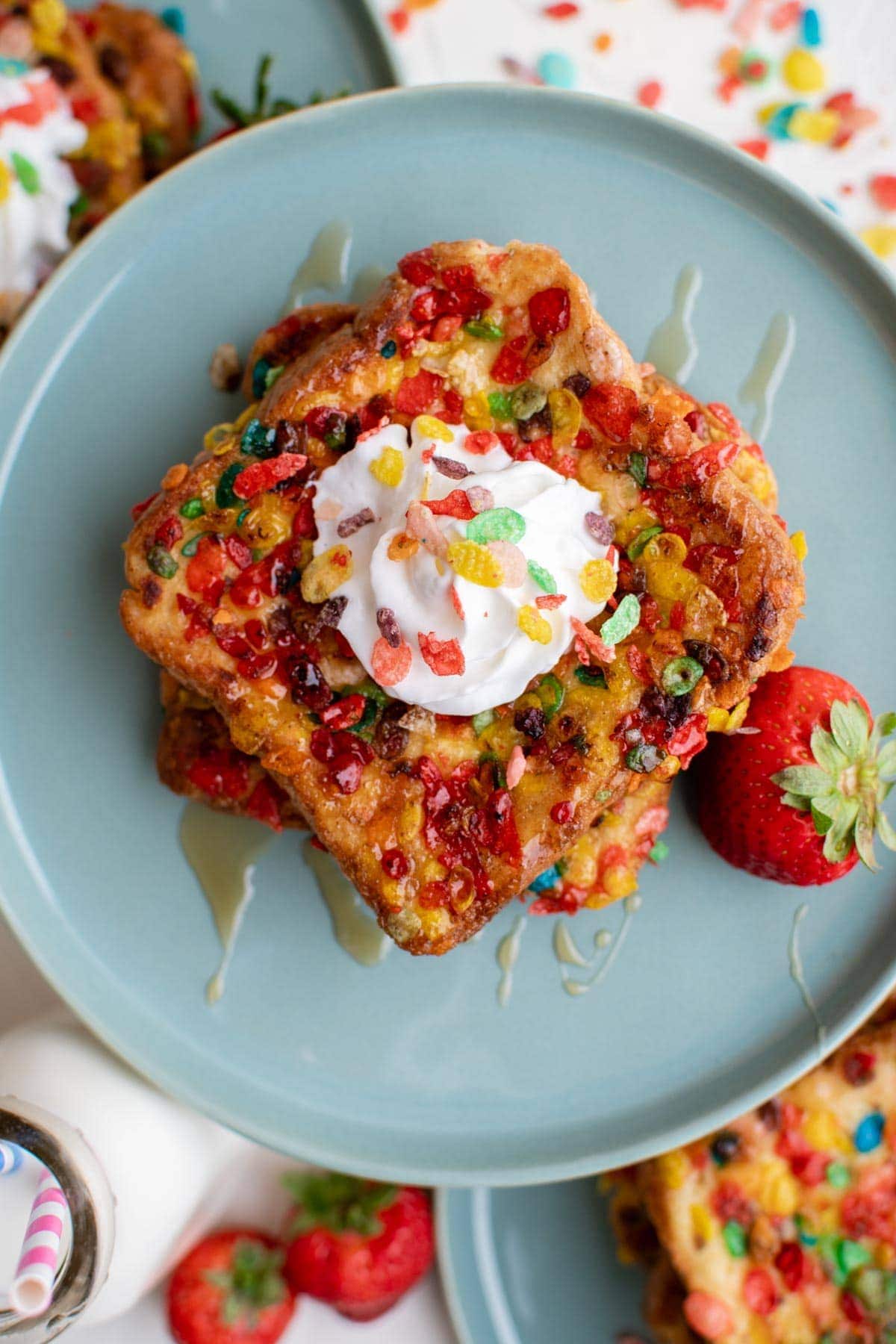 blue plate, french toast with fruity pebbles, strawberries, whipped cream