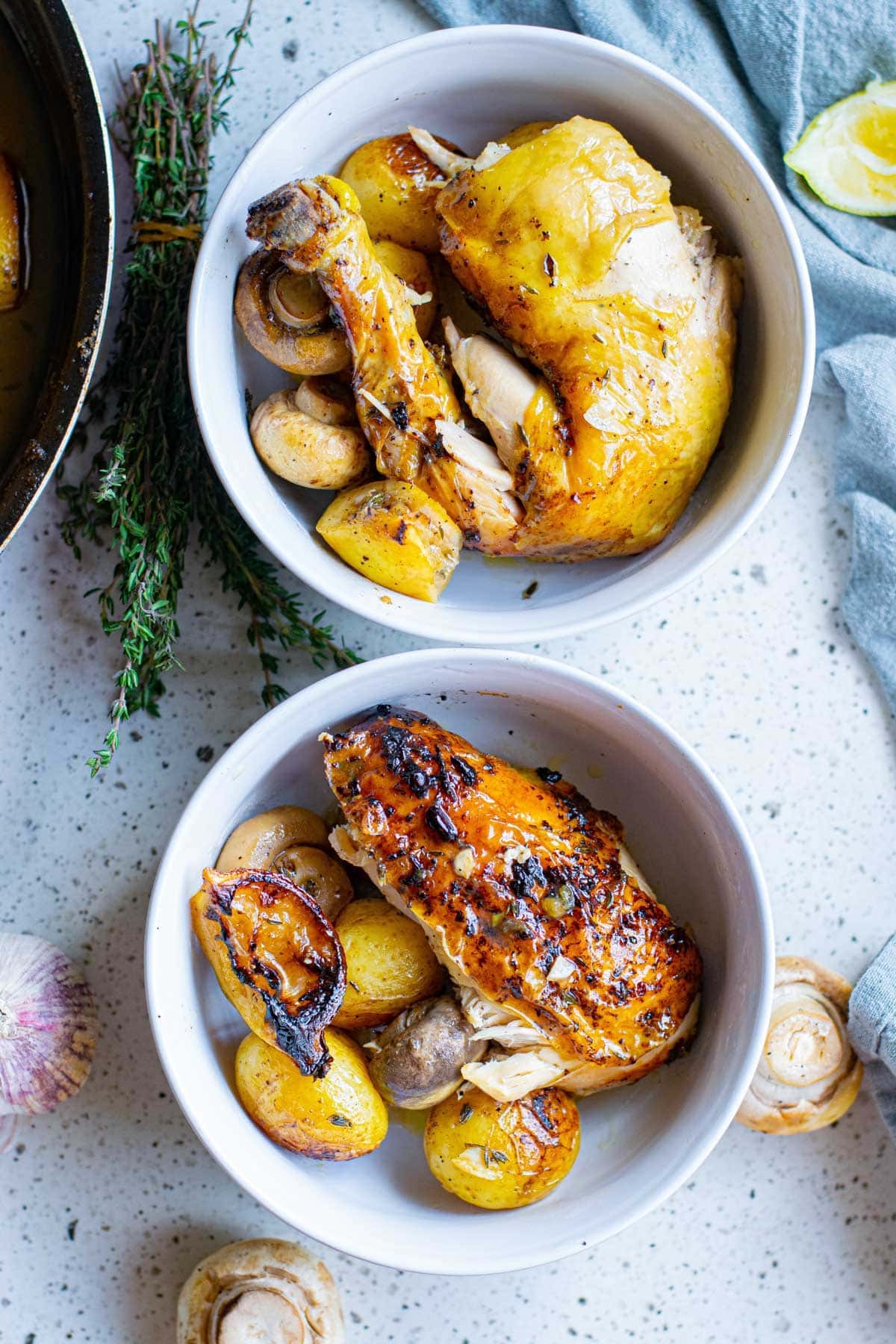white bowls with chicken pieces, mushrooms and lemons
