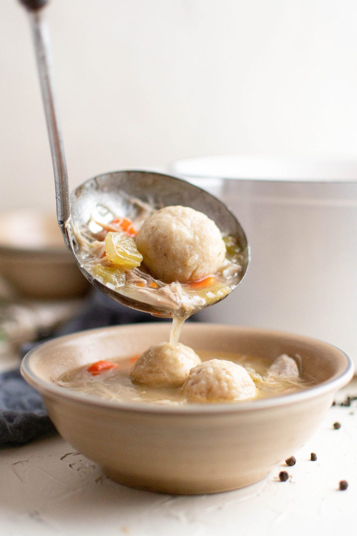 ladle, soup, matzo balls, white bowl