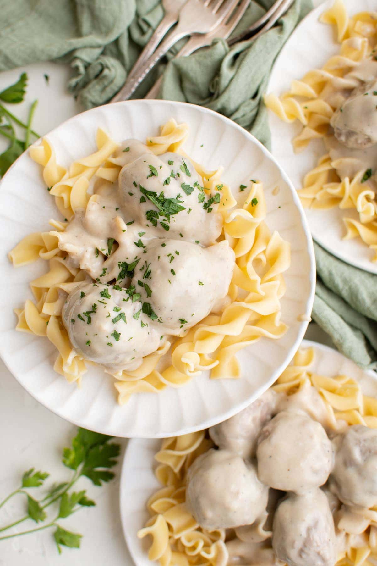 white plates with meatballs, gravy and noodles