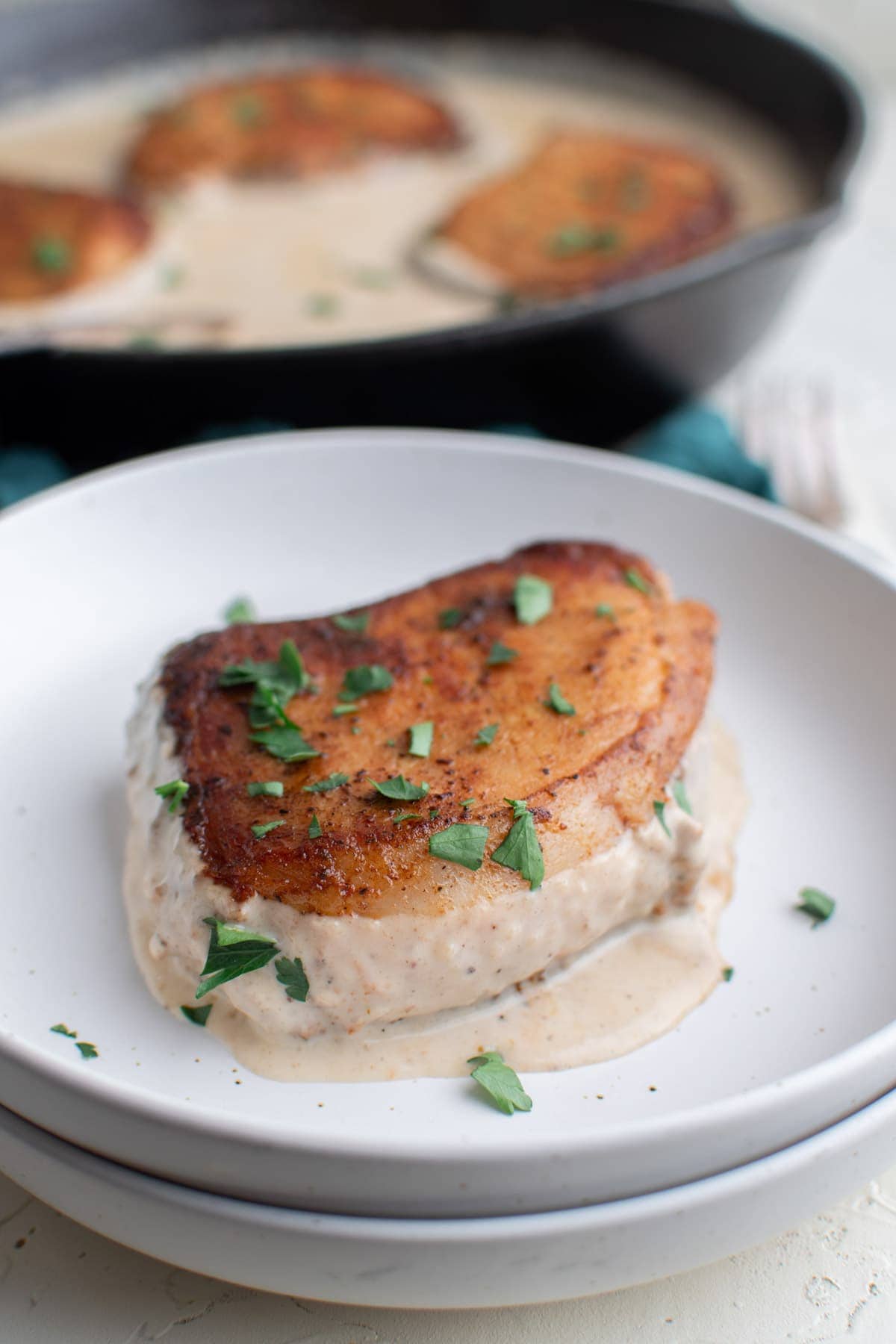 white plates, pork chops, gravy, parsley