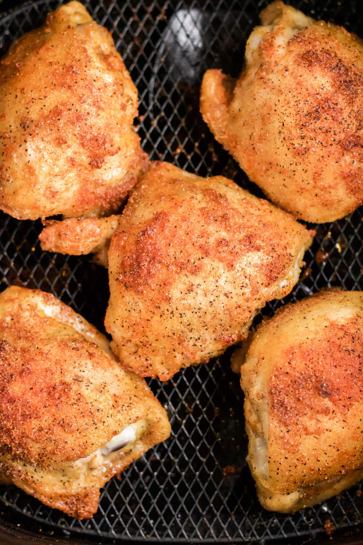 chicken thighs with crispy skin in air fryer basket