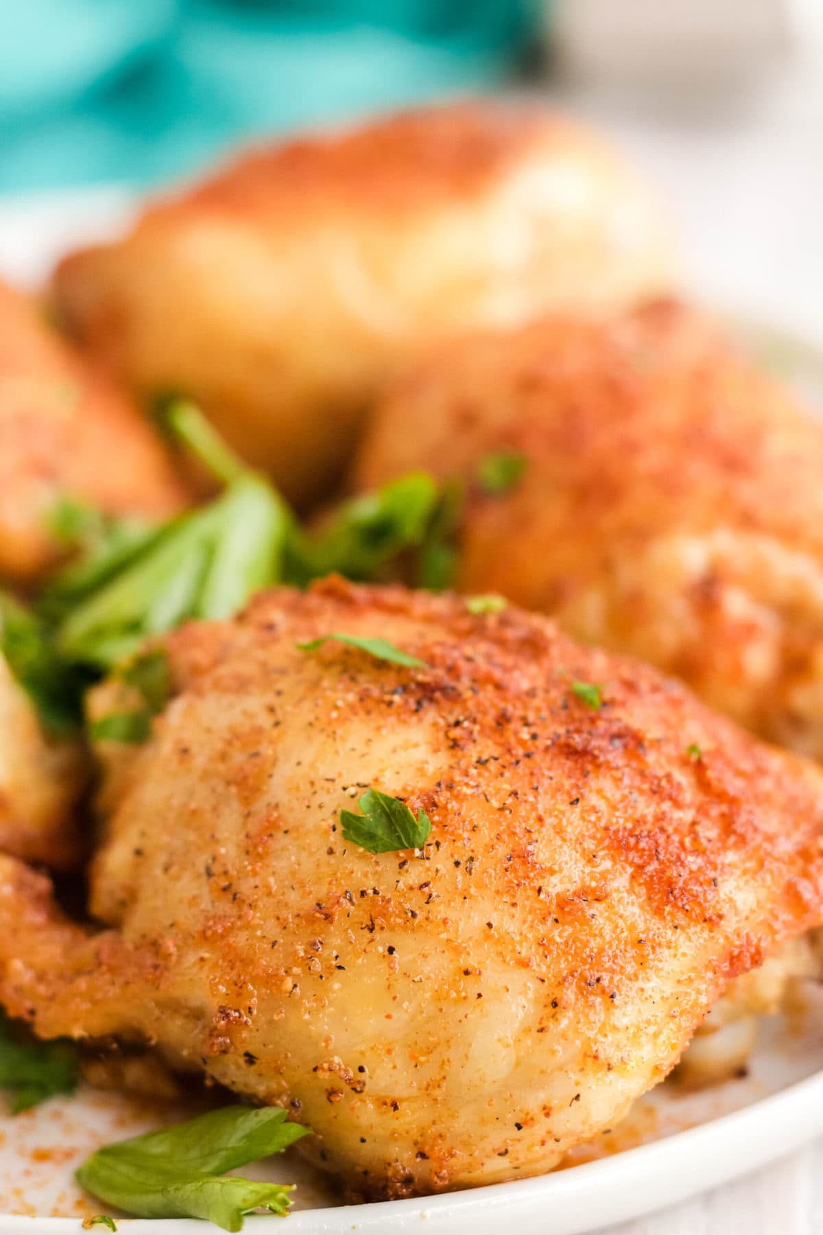 crispy skinned chicken thighs, white plate, parsley, air fryer