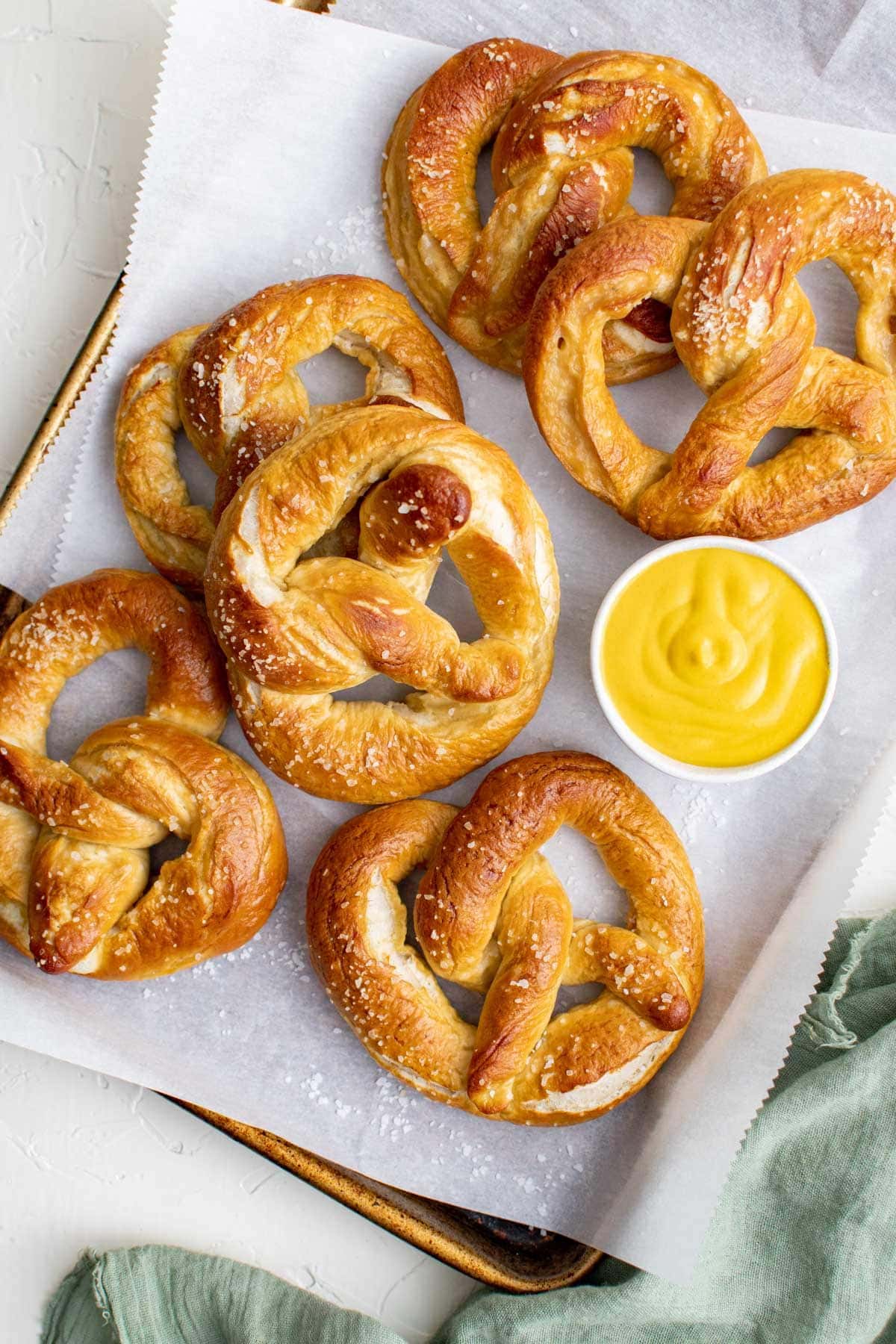 homemade baked pretzels, parchment paper, baking sheet, dish of mustard