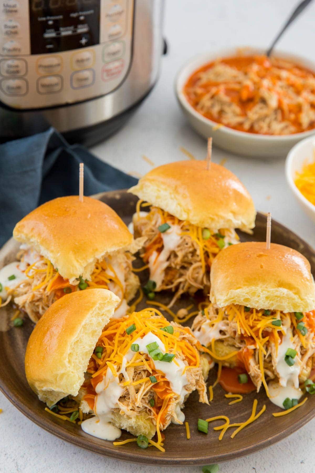 buffalo chicken sliders, shredded cheese, ranch dressing, green onions, instant pot, white bowls