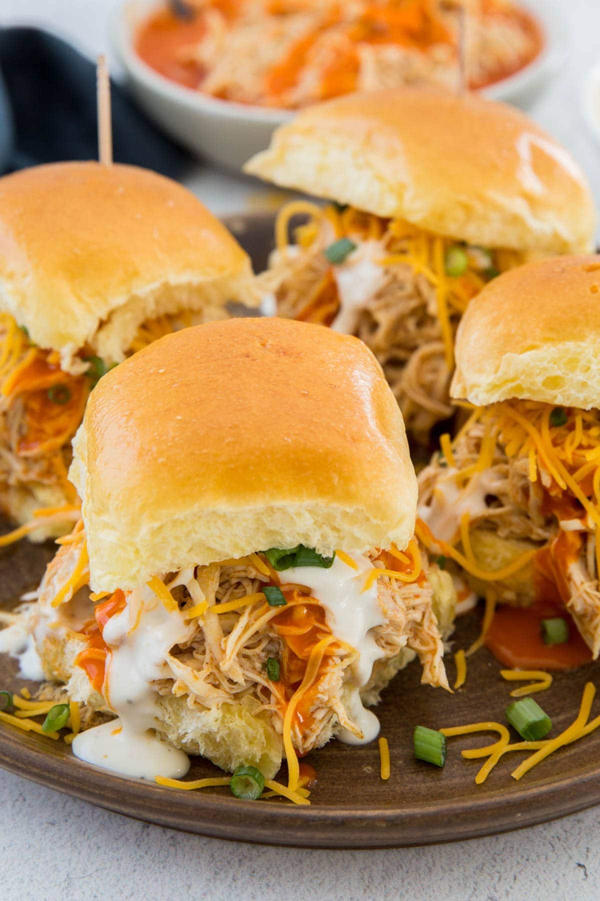 buffalo chicken on slider rolls with green onions, ranch and cheese, toothpicks