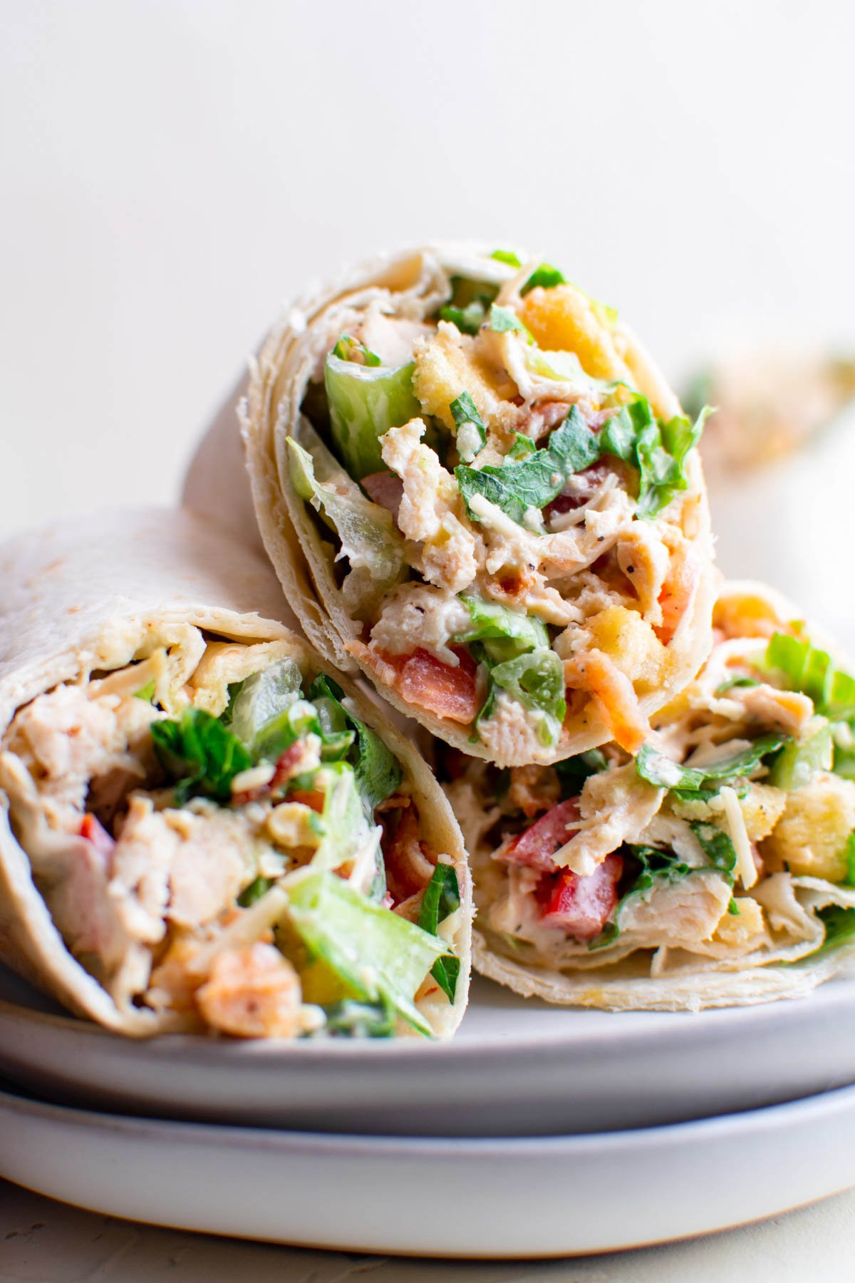 chicken caesar salad in tortillas with toothpicks, white plates