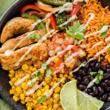 bowl with chicken fajitas bowl with limes, corn, black beans rice and peppers