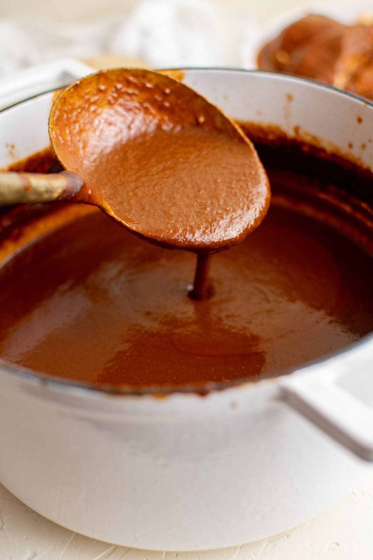 white pot with mole sauce and a large spoon