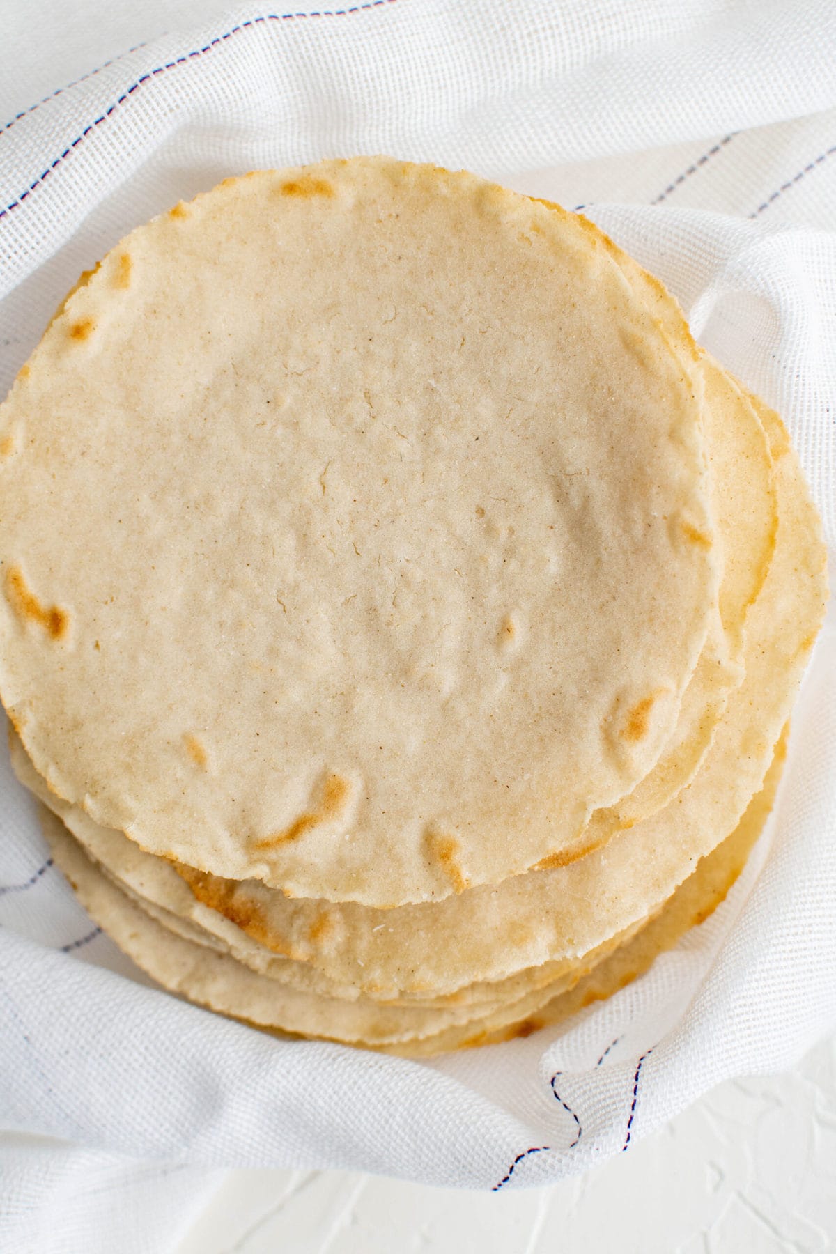 overhead shot of corn tortillas in a white towel