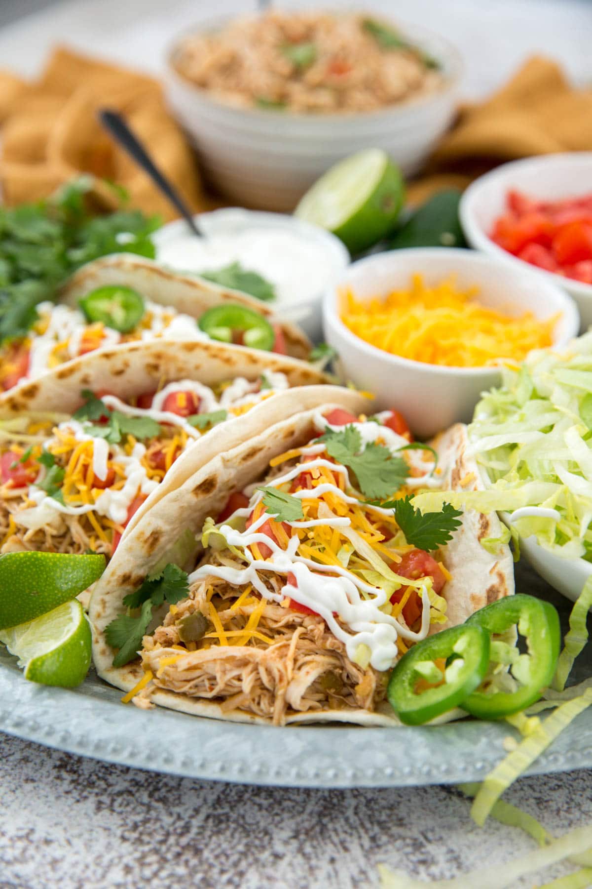 shredded chicken tacos, lettuce, tomatoes, cheese, sour cream