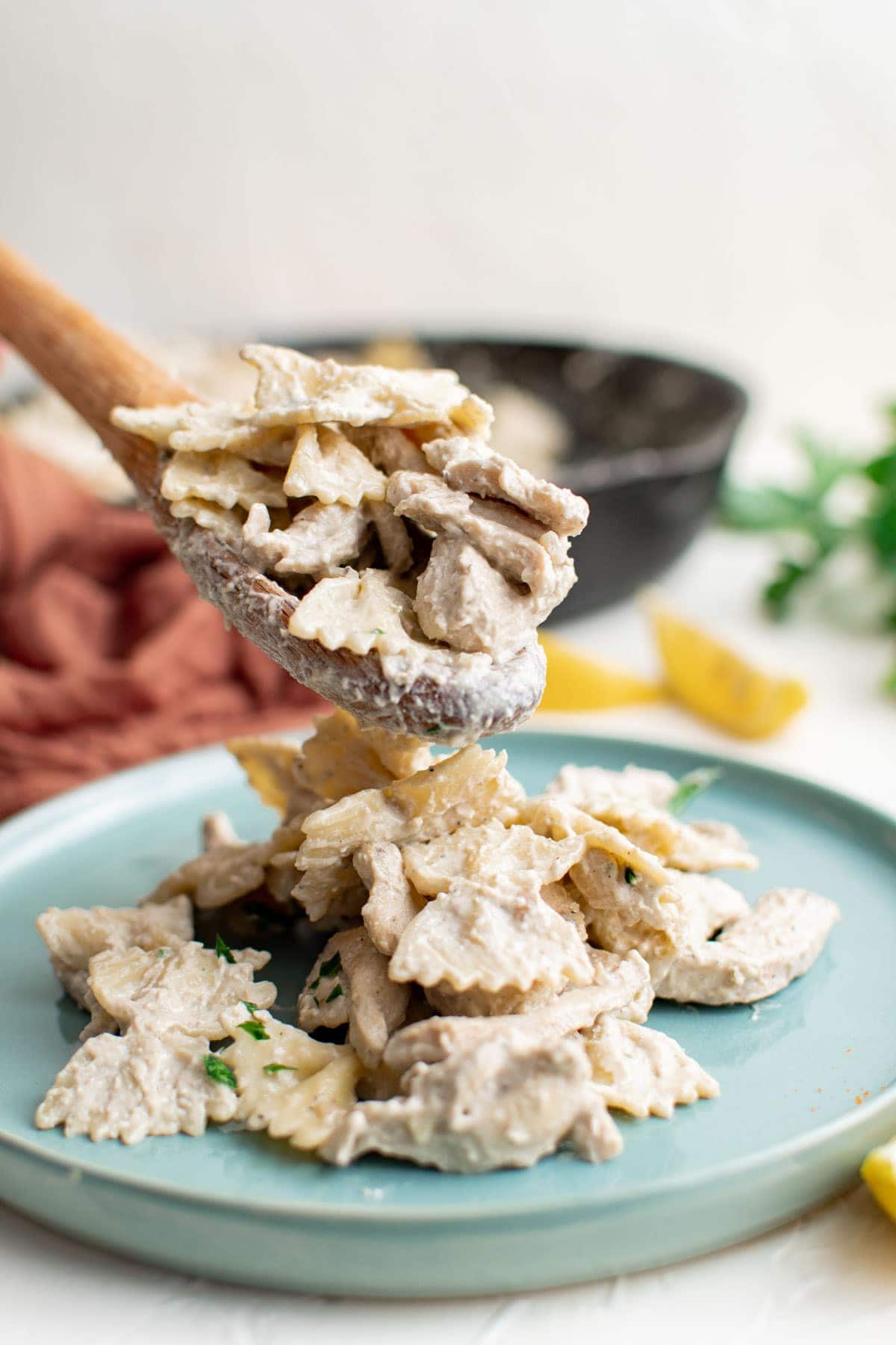 creamy chicken pasta, lemons, wooden spoon