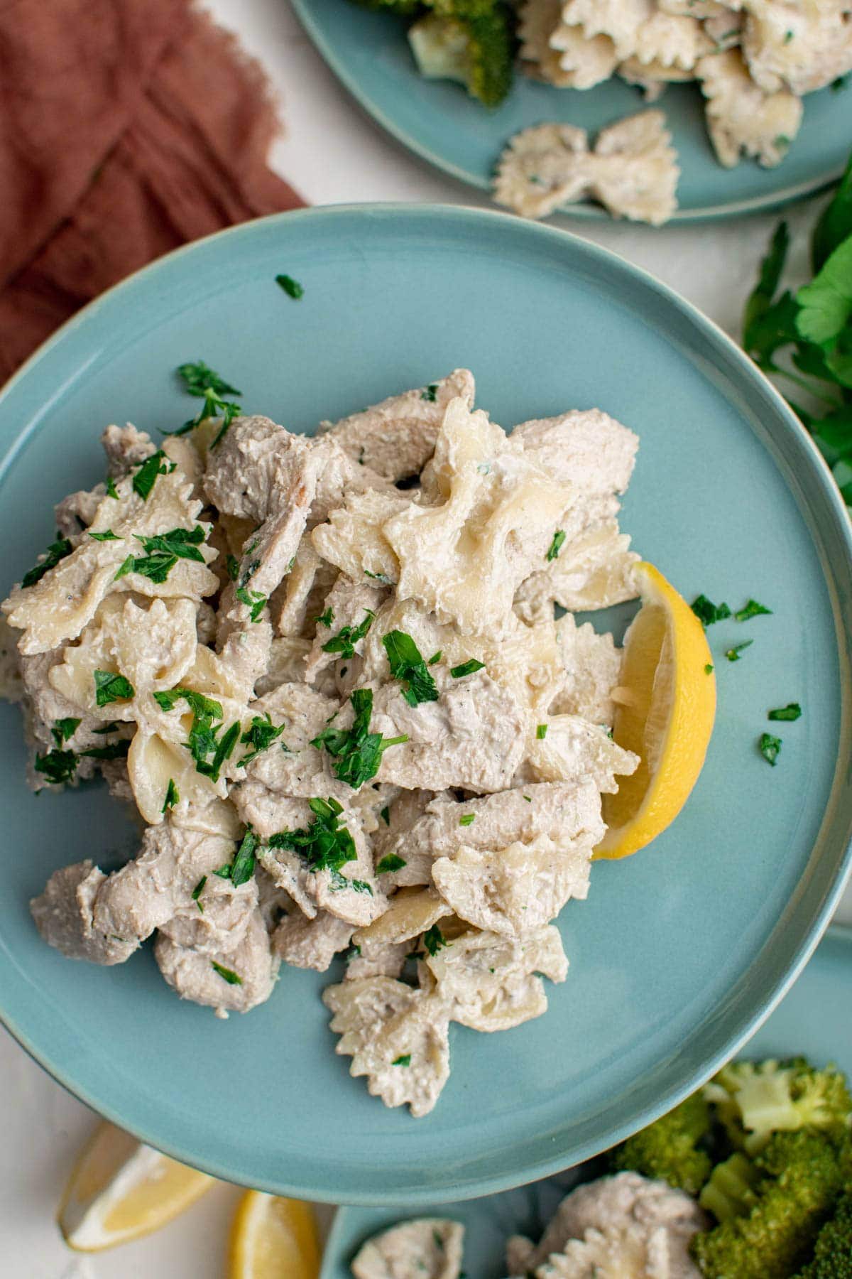 lemon chicken pasta on blue plaes with parsley
