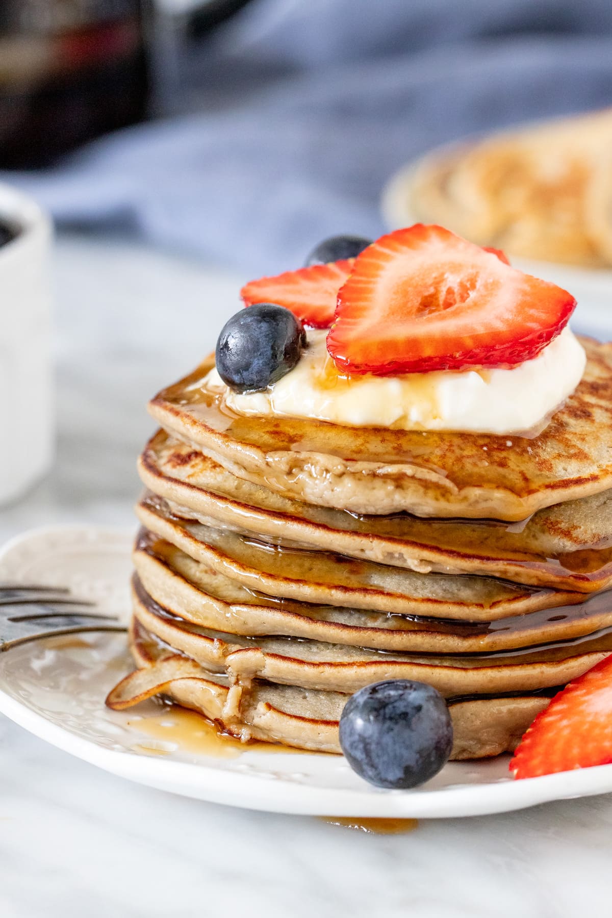 Stack of protein pancakes with syrup dripping down the sides. 