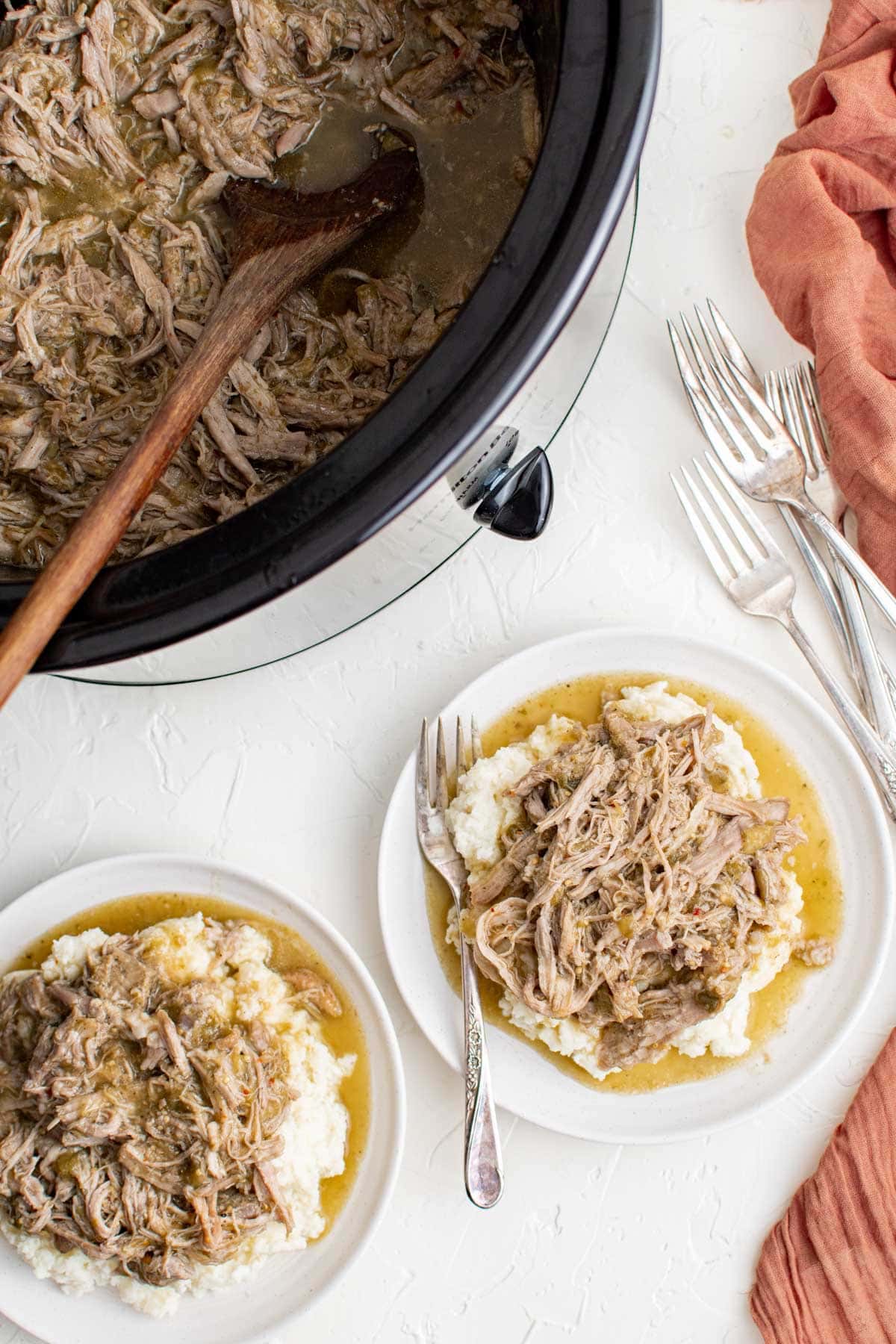 white plates, forks, red napkin, slow cooker, chile verde, mashed potatoes