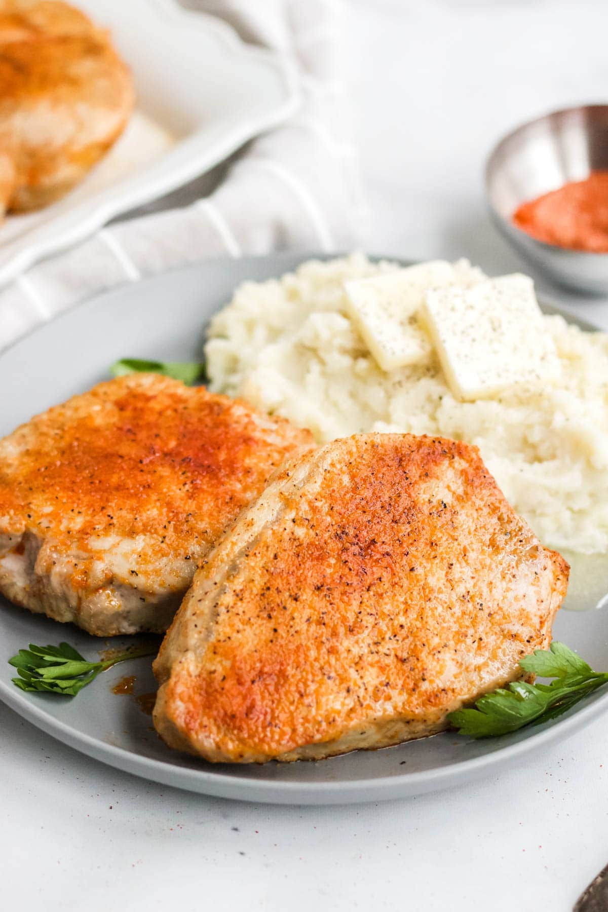 plate with mashed potatoes, pork chops and parsley