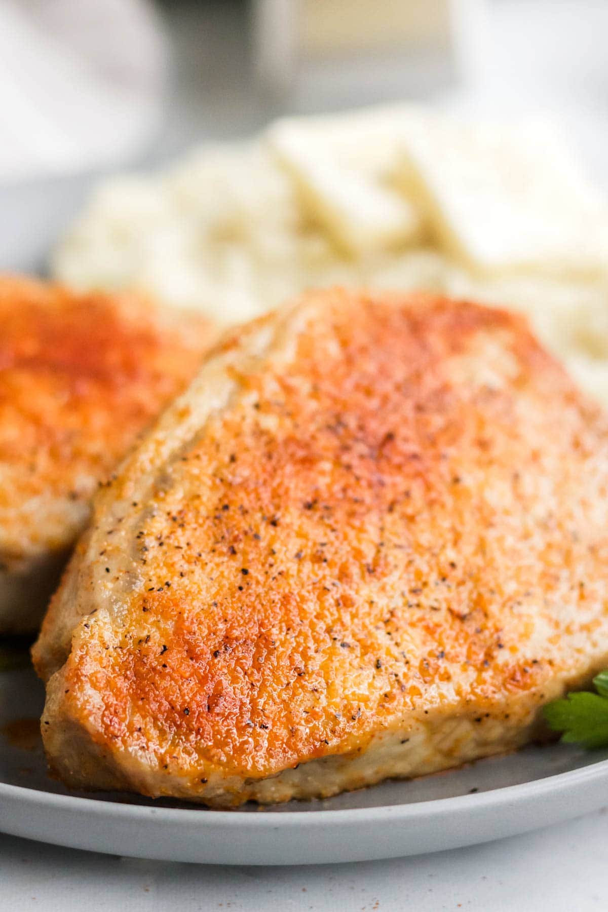 close up of air fryer pork chop on a plate, mashed potatoes