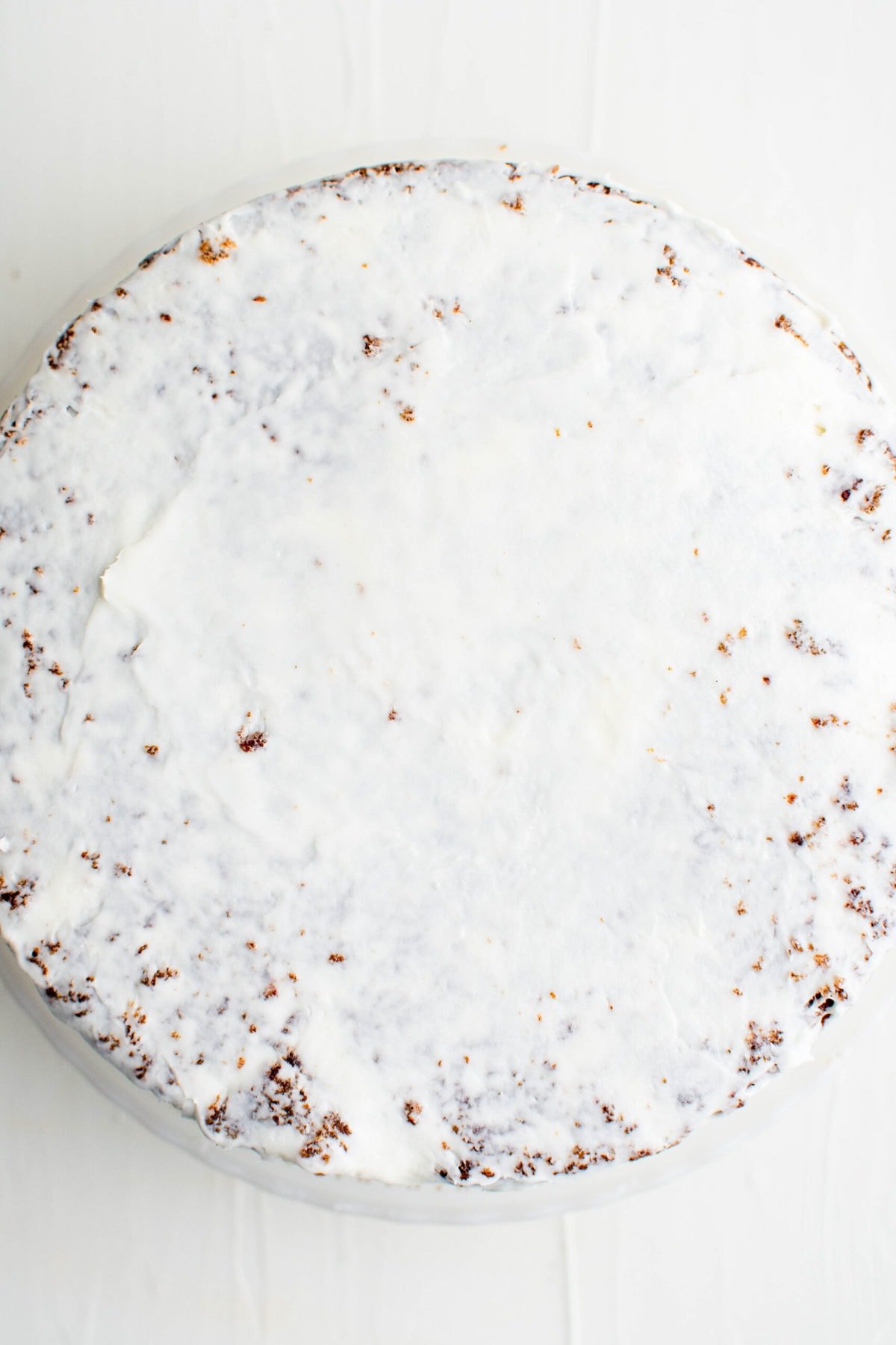 carrot cake with crumb coat layer of frosting