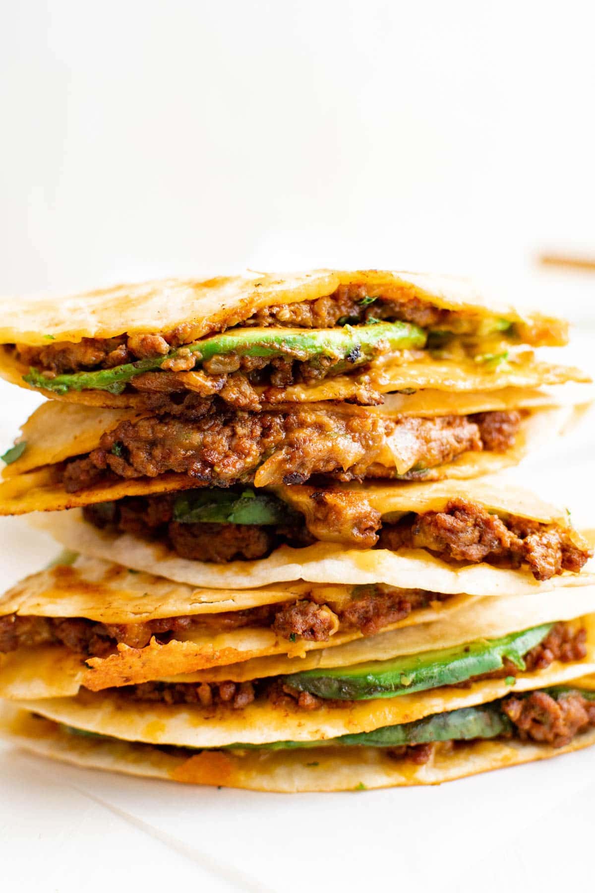 stack of ground beef quesadillas with avocado