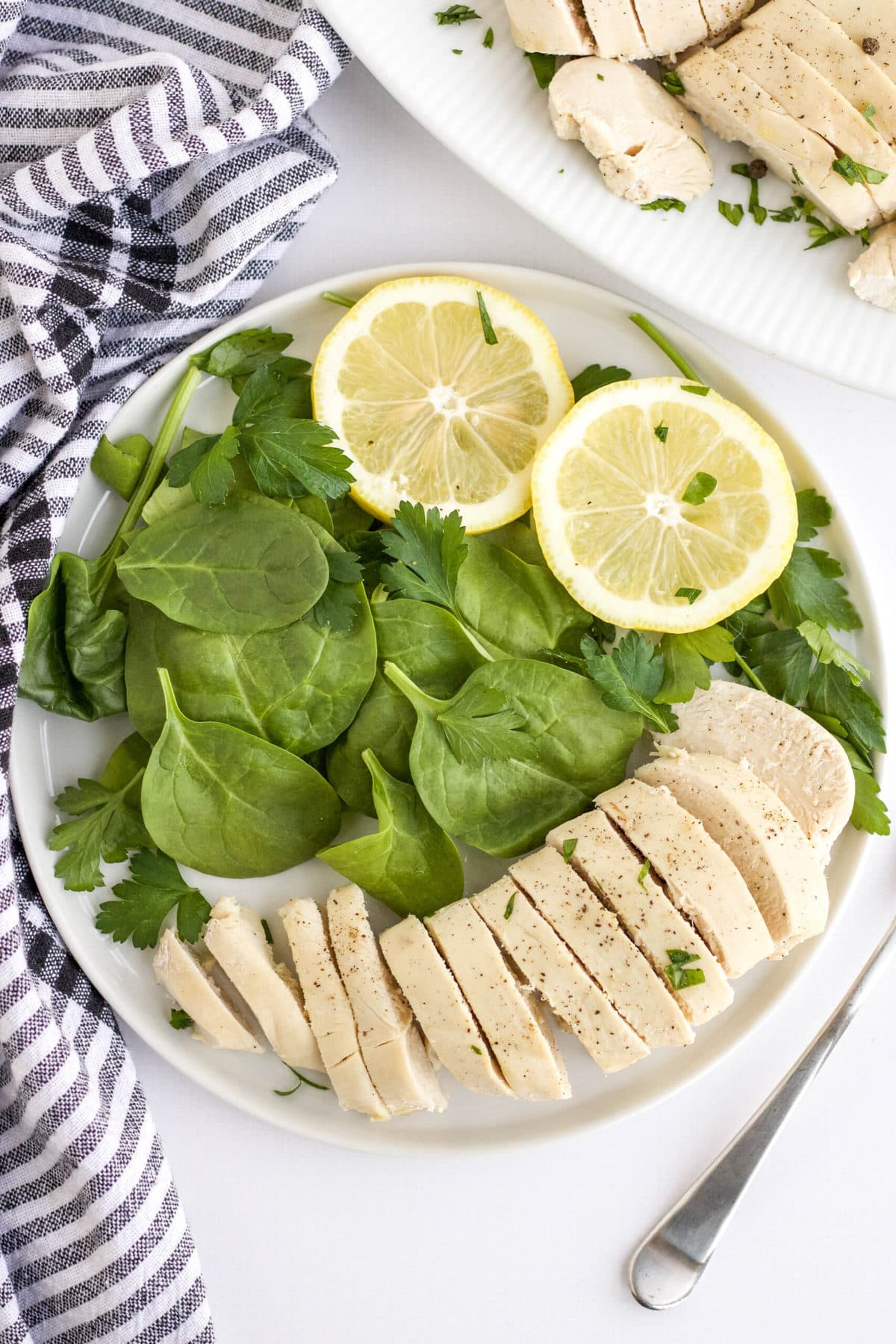 sliced chicken, salad, lemons, blue and white striped napkin