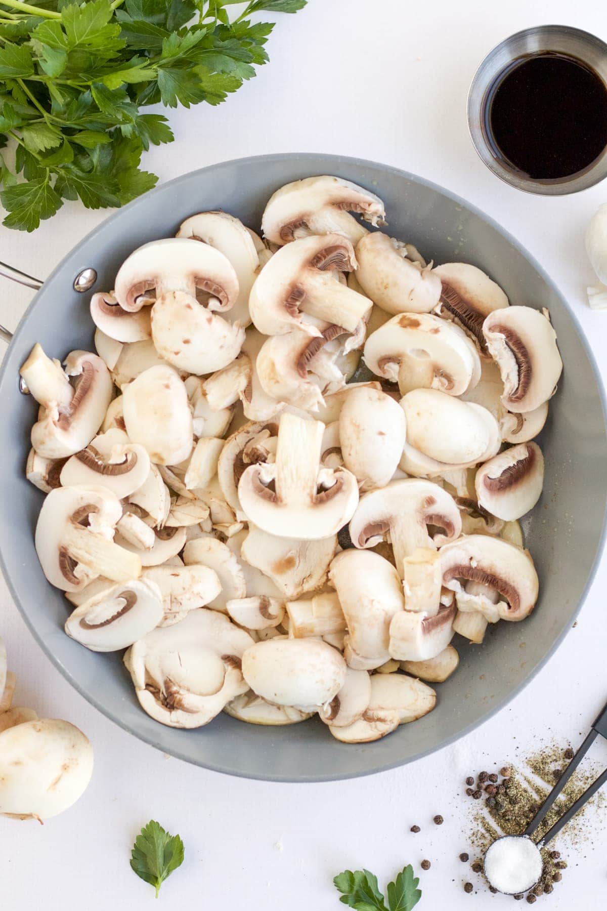 Raw mushrooms in pan in preparation to make sauteed mushrooms