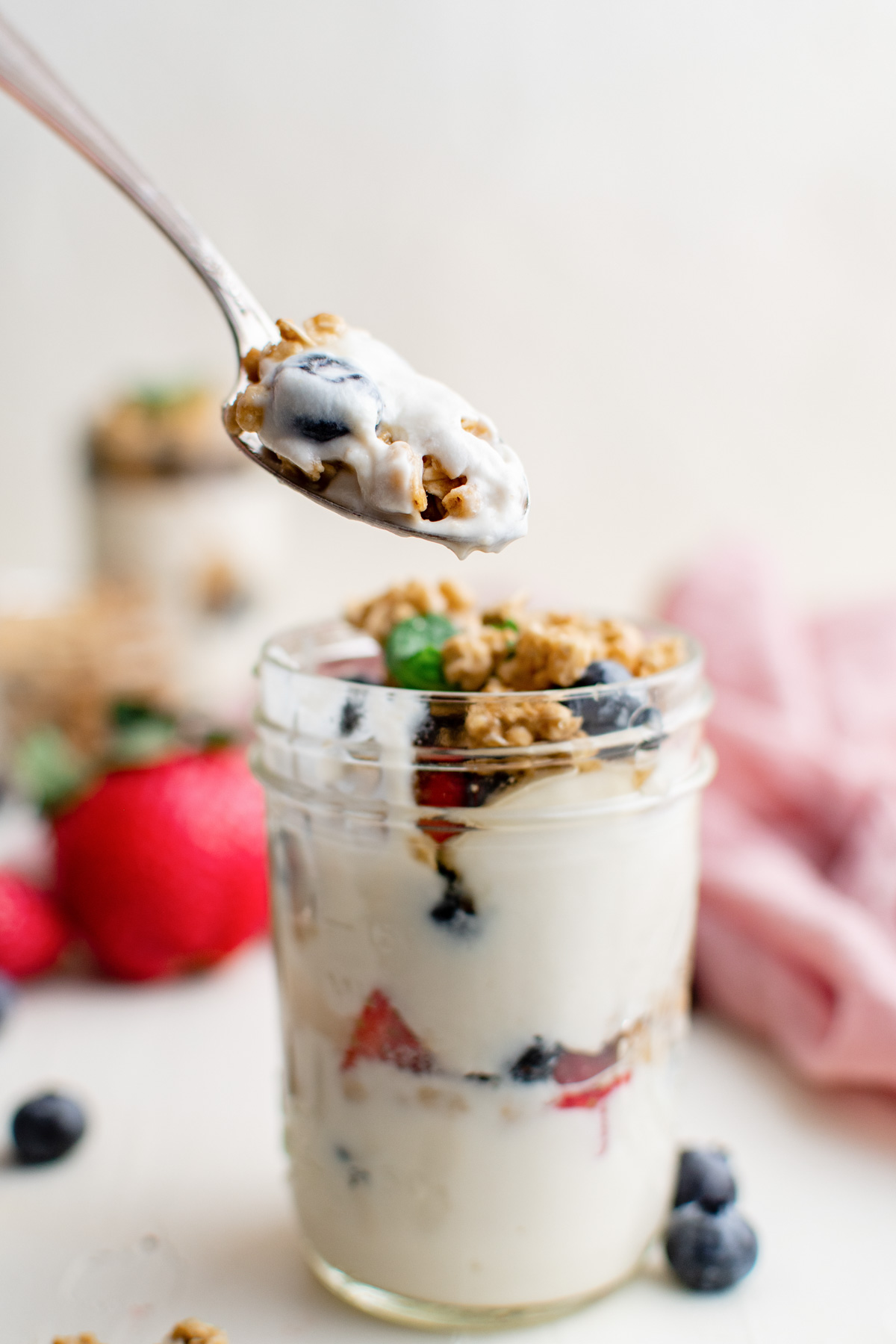 glass jar with yogurt parfait, spoon