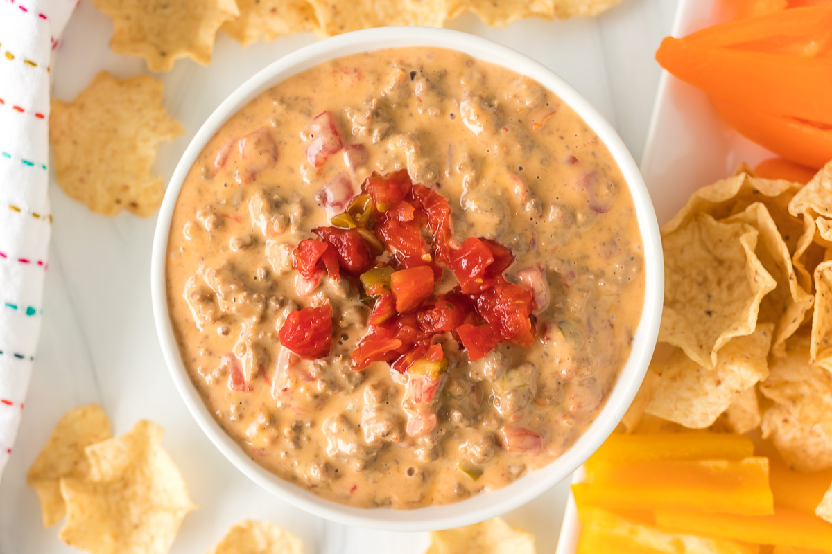 overhead shot of cheesy rotel dip topped with diced tomatoes