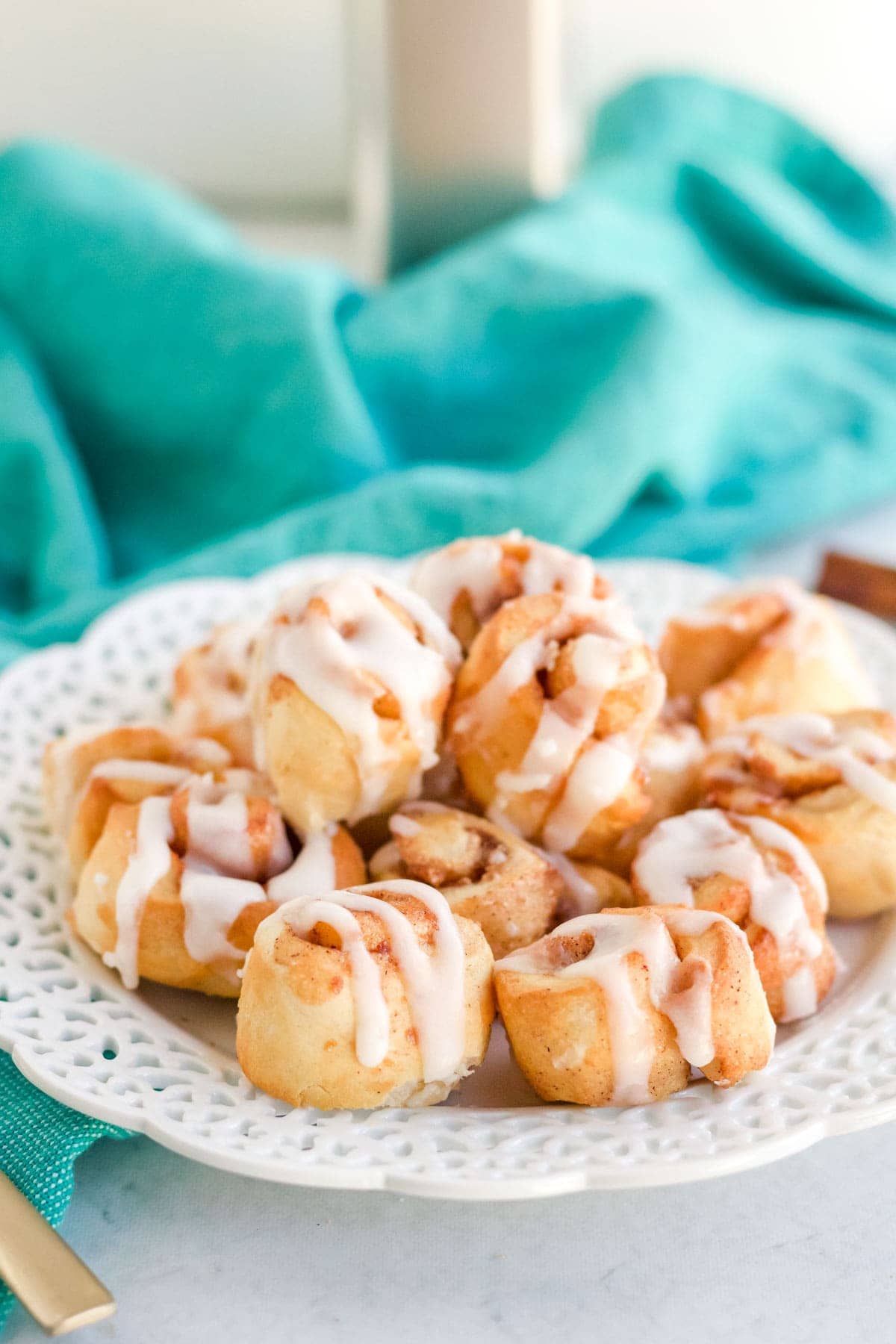 mini cinnamon rolls on a white platter, blue towel, air fryer