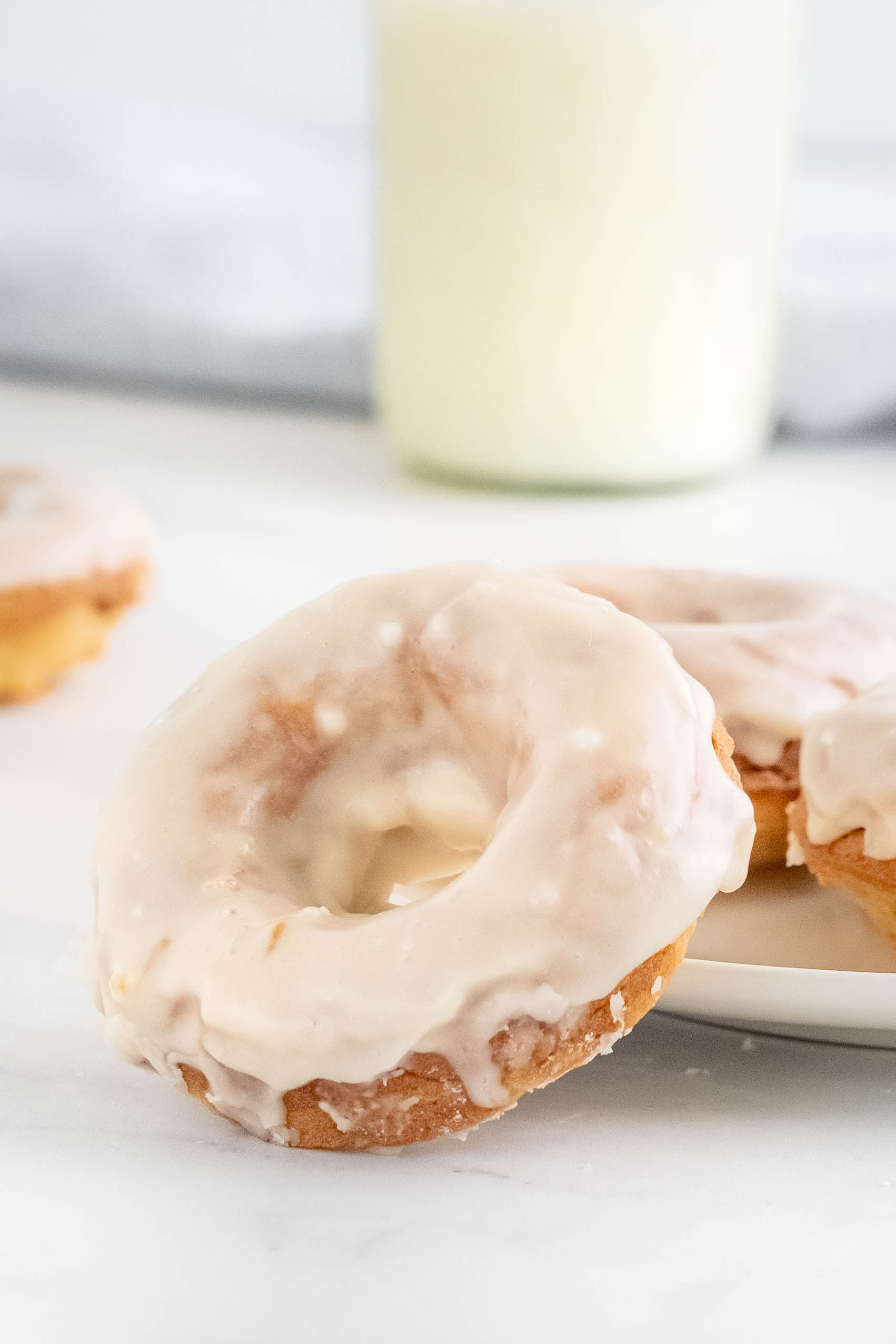 glass of milk, baked donut with vanilla glae