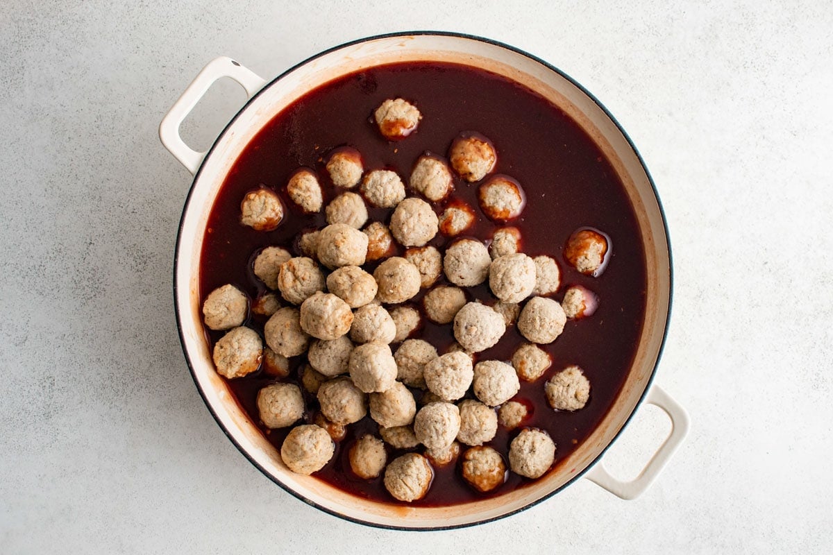 Frozen meatballs in a dark bbq grape jelly sauce.