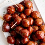 Grape jelly meatballs stacked on a platter (social media image).
