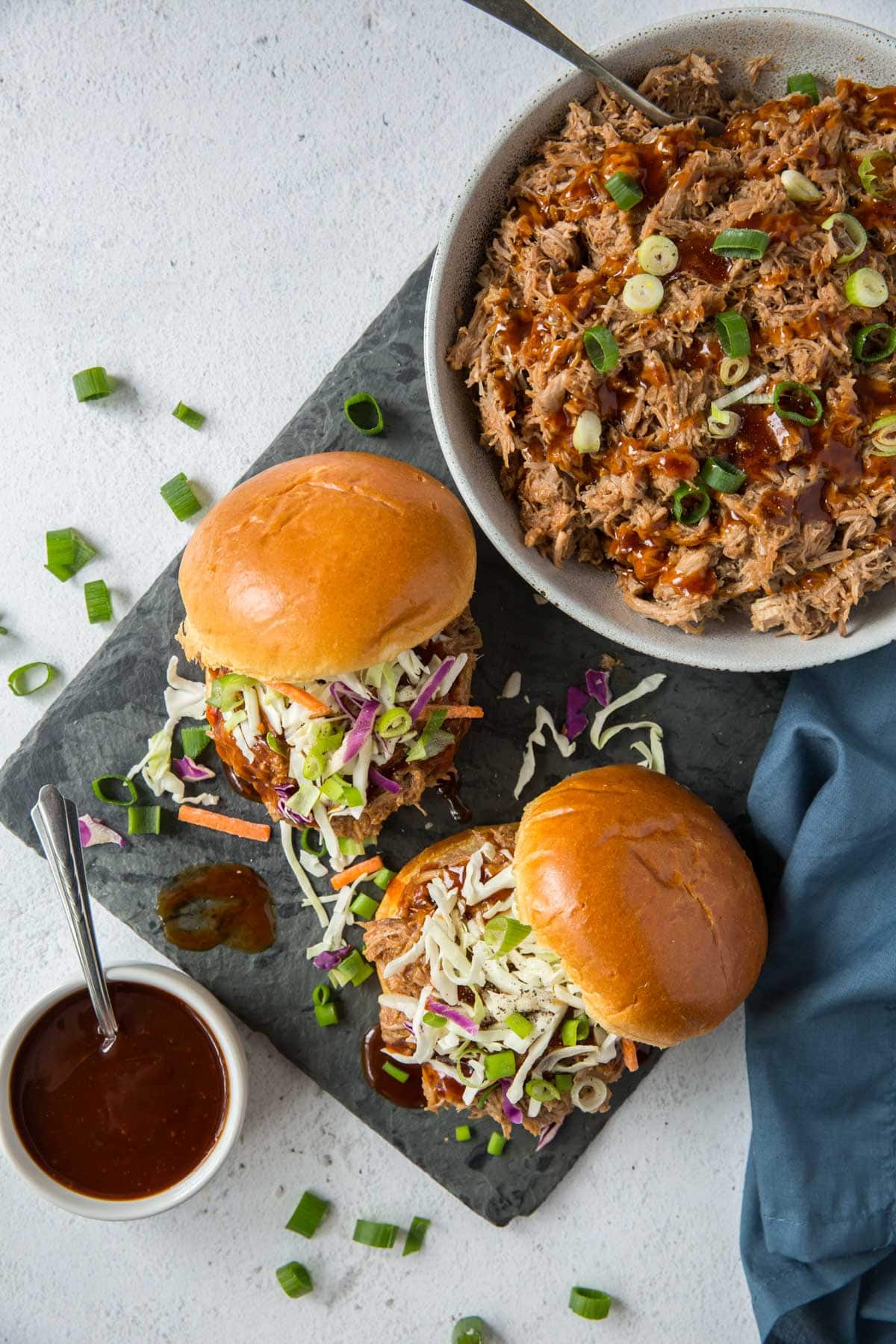 sandwiches with pulled pork, bowl of bbq pulled pork, bbw sauce, green onions