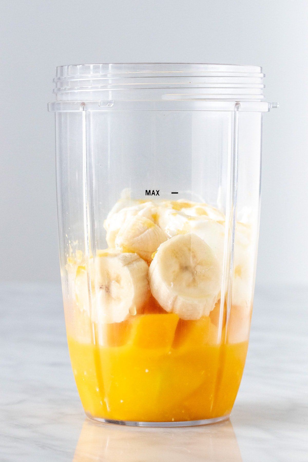 Blender CONTAINER WITH ORANGE JUICE, MANGO AND BANANA