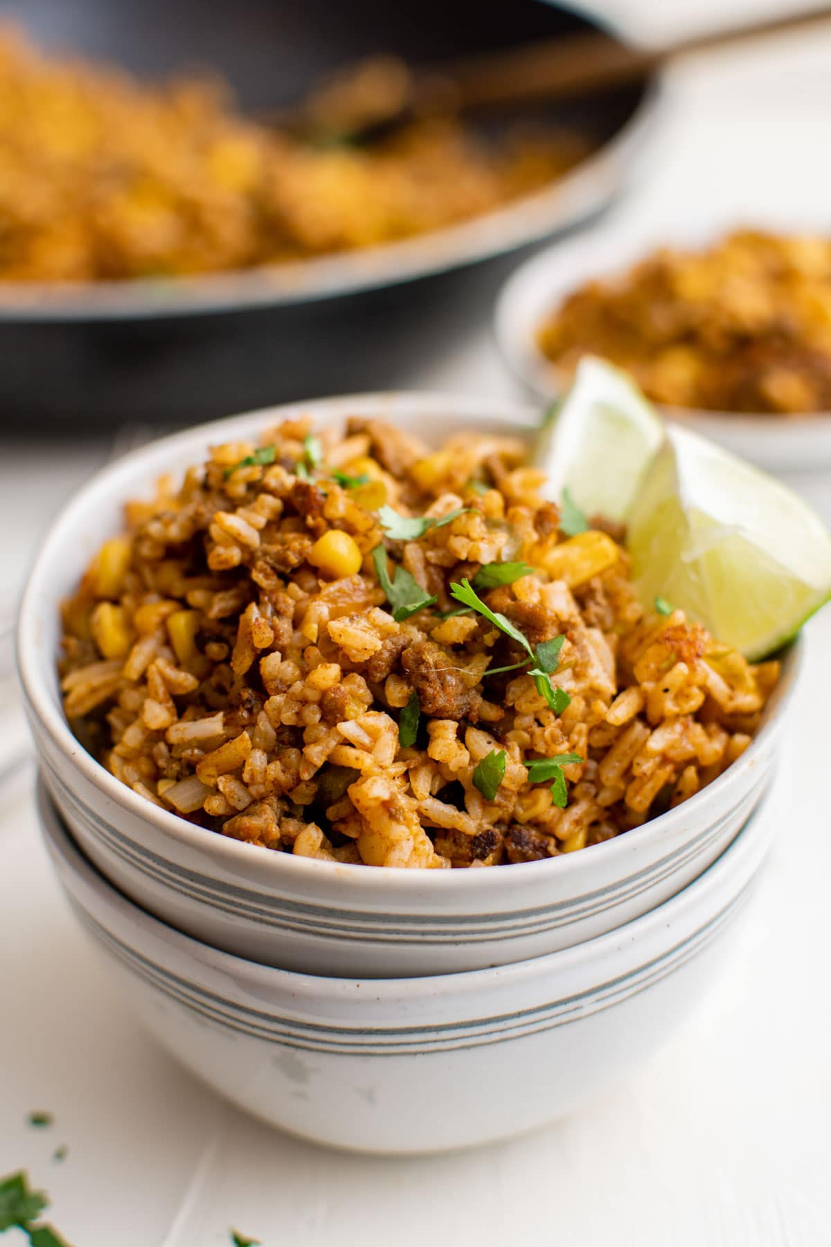 stacked white bowl with mexican friend rice and limes