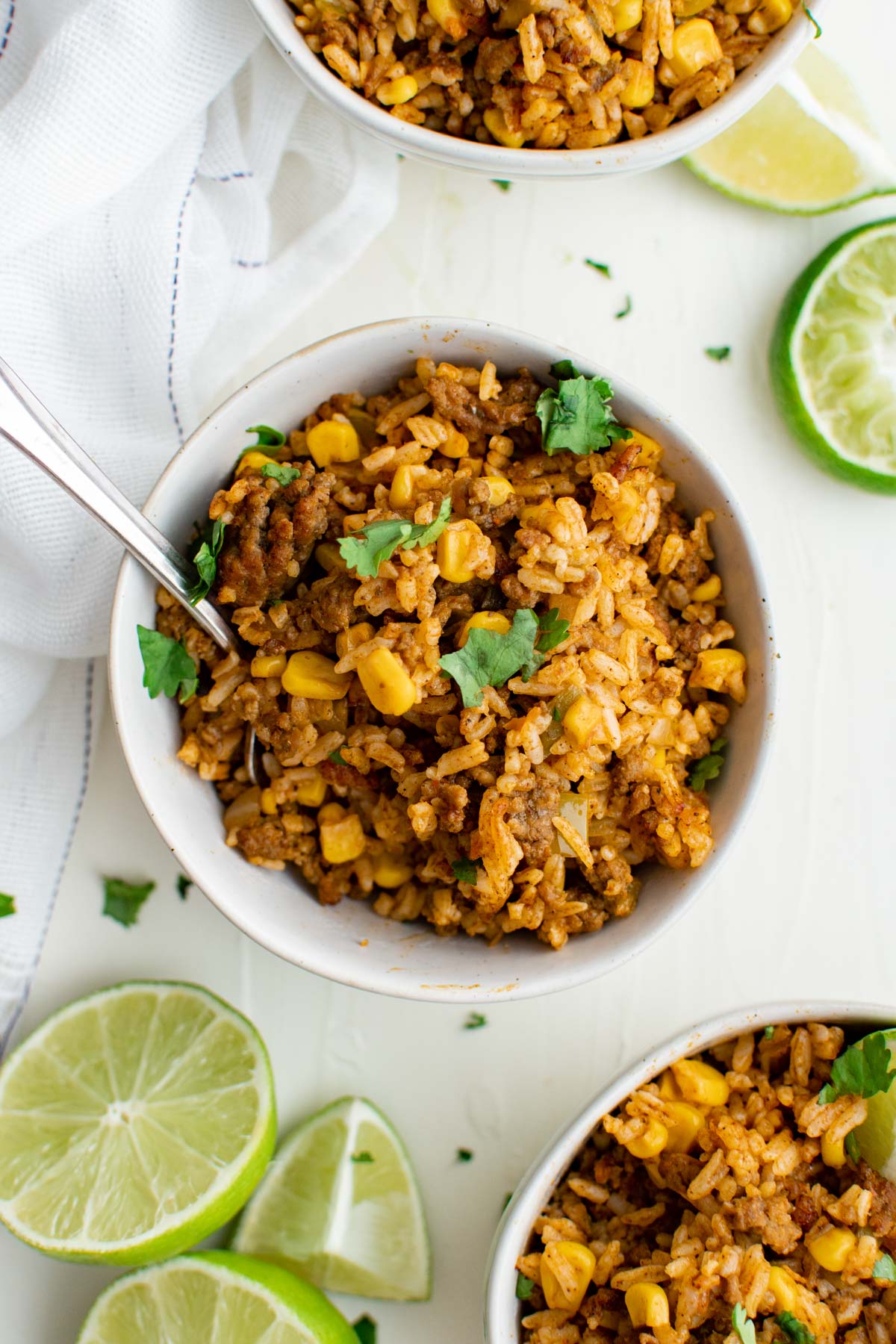 white bowls with mexican fried rice, limes and cilantro