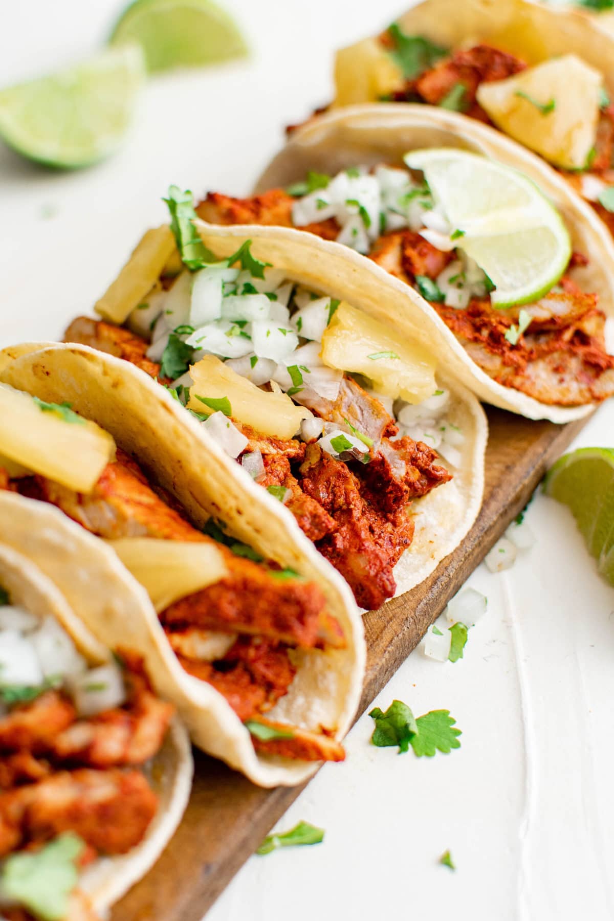 tacos al pastor with limes, pineapple and cilantro