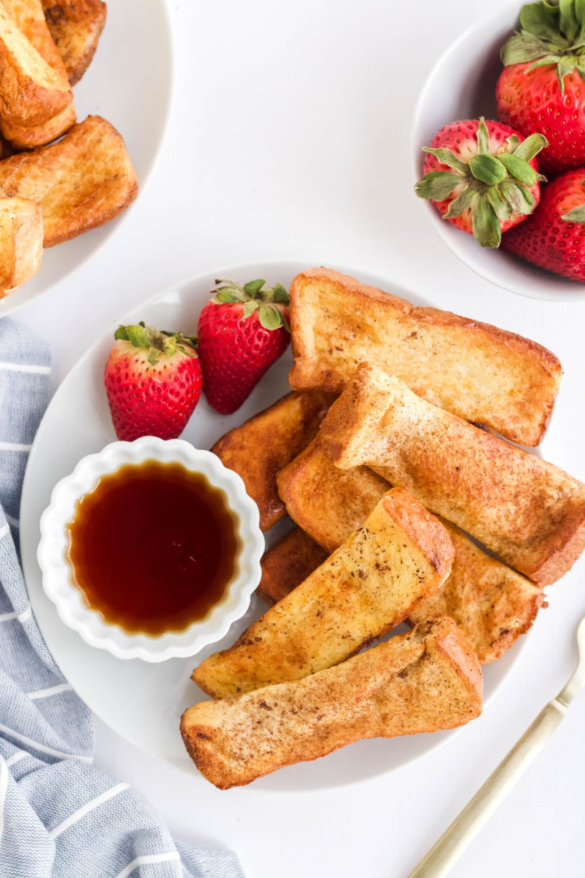 sticks of french on white plate, strawberries dish of syrup