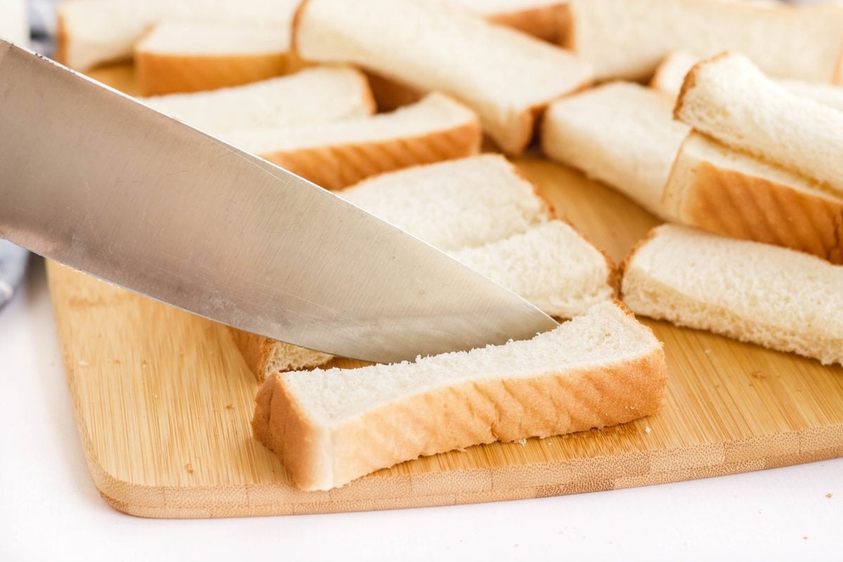 bread on a cutting board, knife sliceing