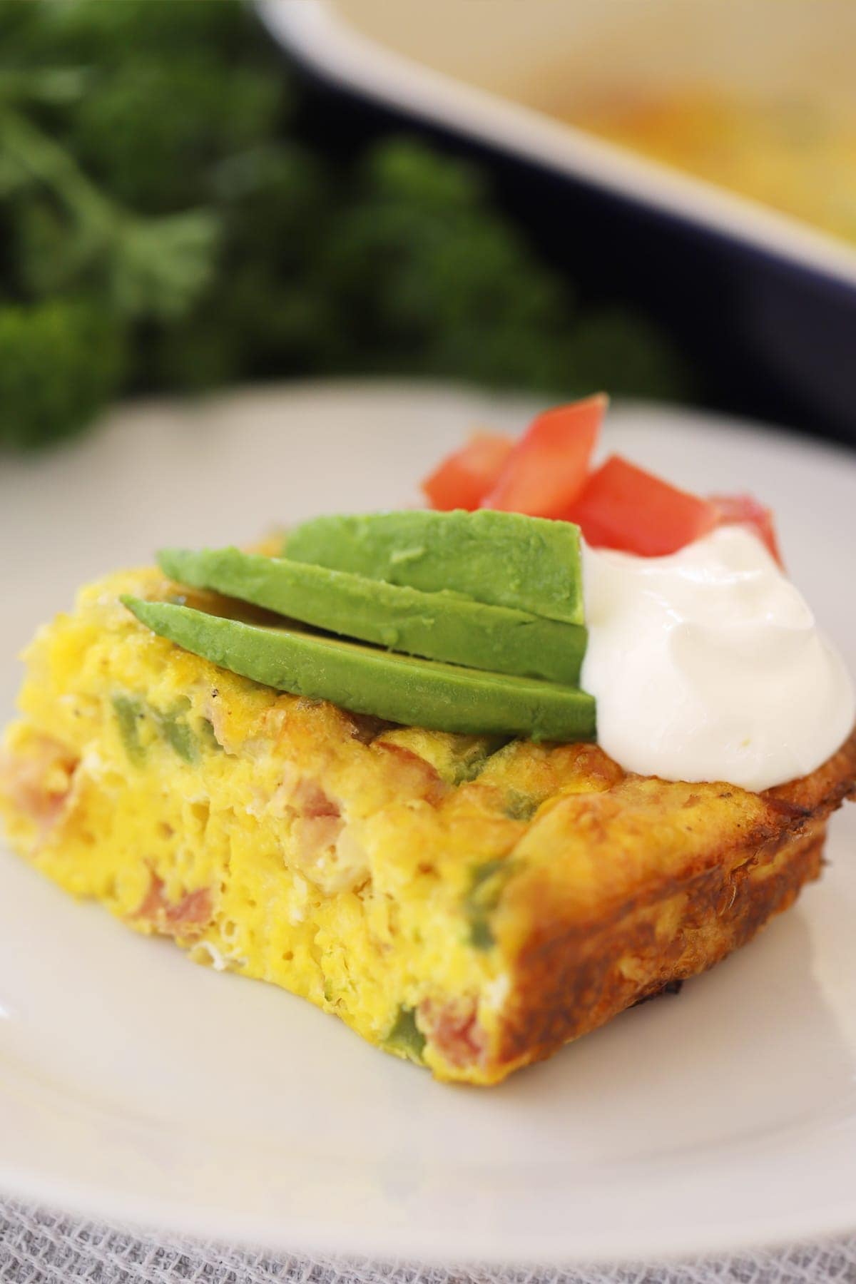 a square piece of a baked Denver omelet on a white plate