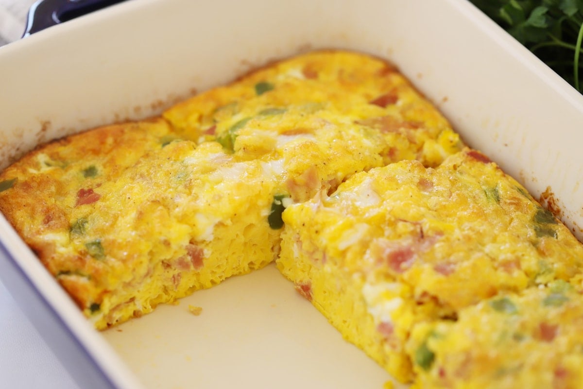 Baked Denver Omelet in a glass baking dish with 2 pieces removed