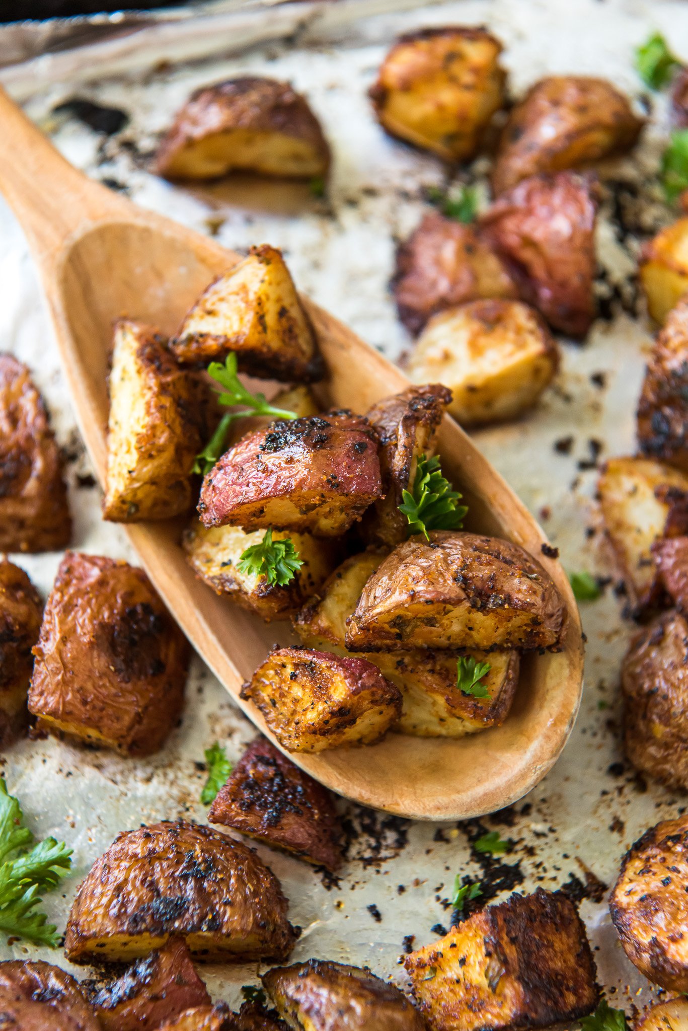 roasted red potatoes on tray wooden spoon