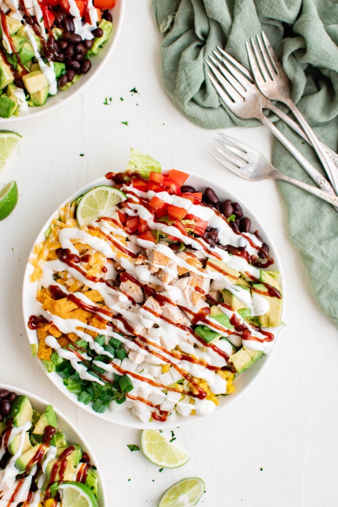 plates with bbq chickn salad, green napkin, forks