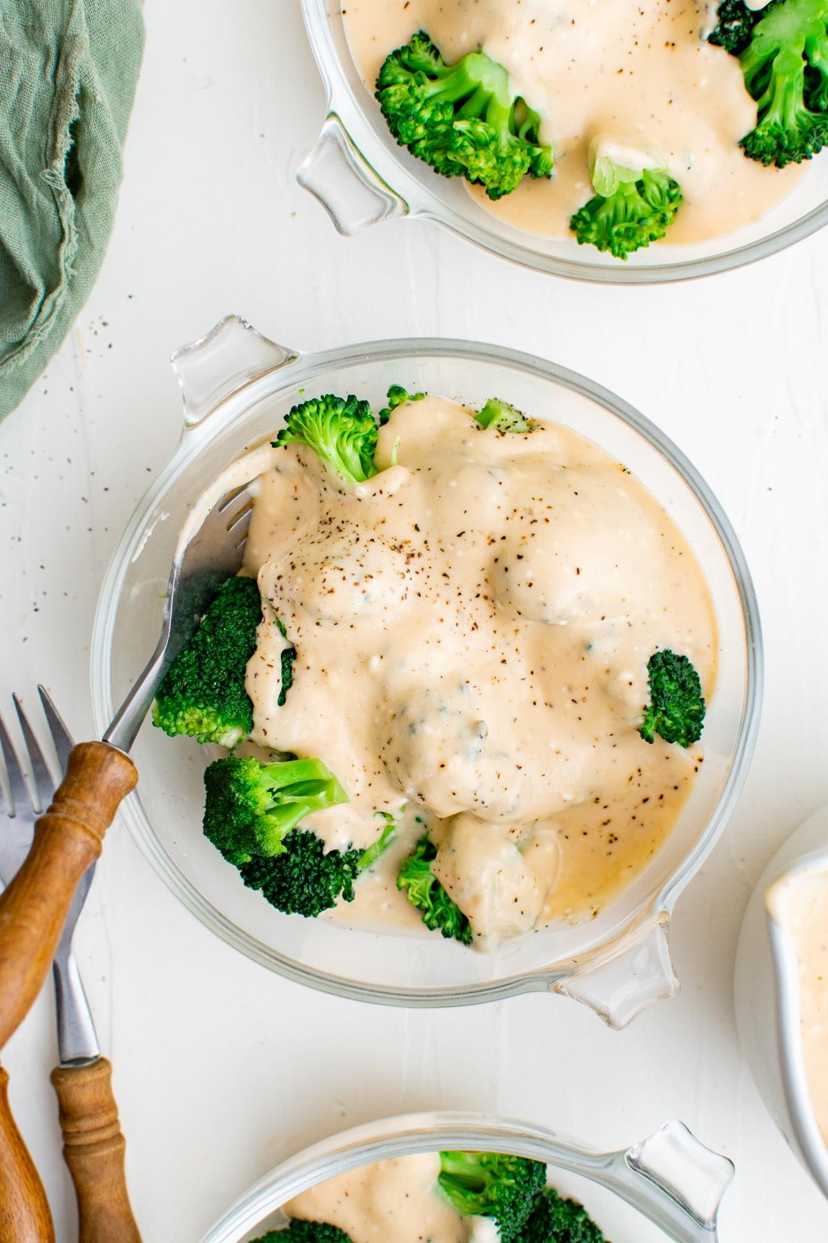 broccoli with cheese sauce in a bowl with a fork