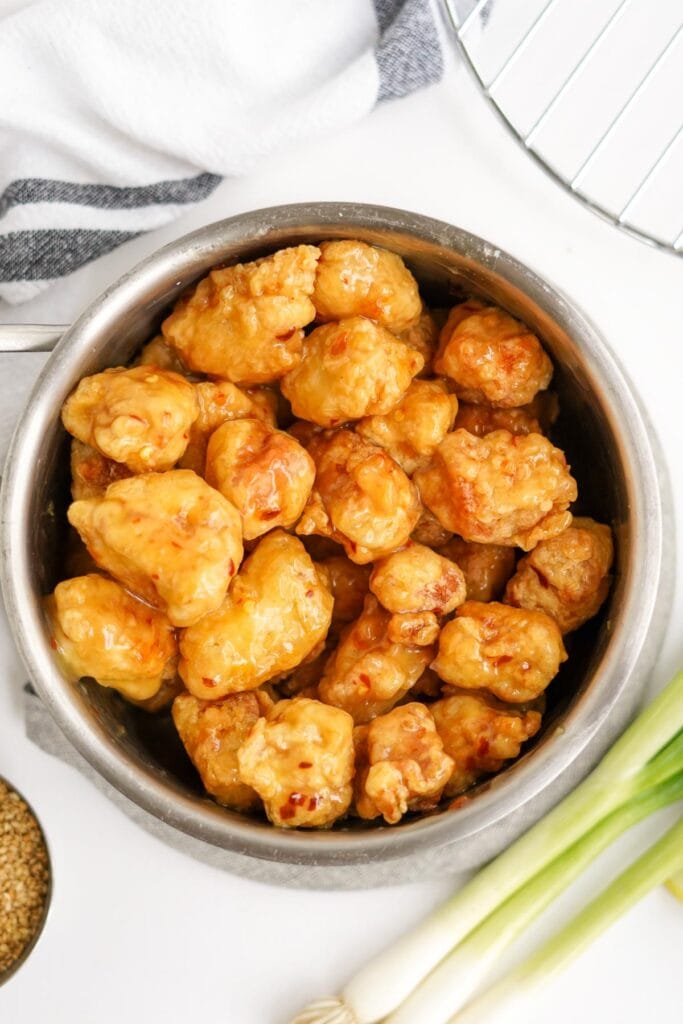 large metal bowl with crispy chinese lemon chicken tossed in lemon sauce