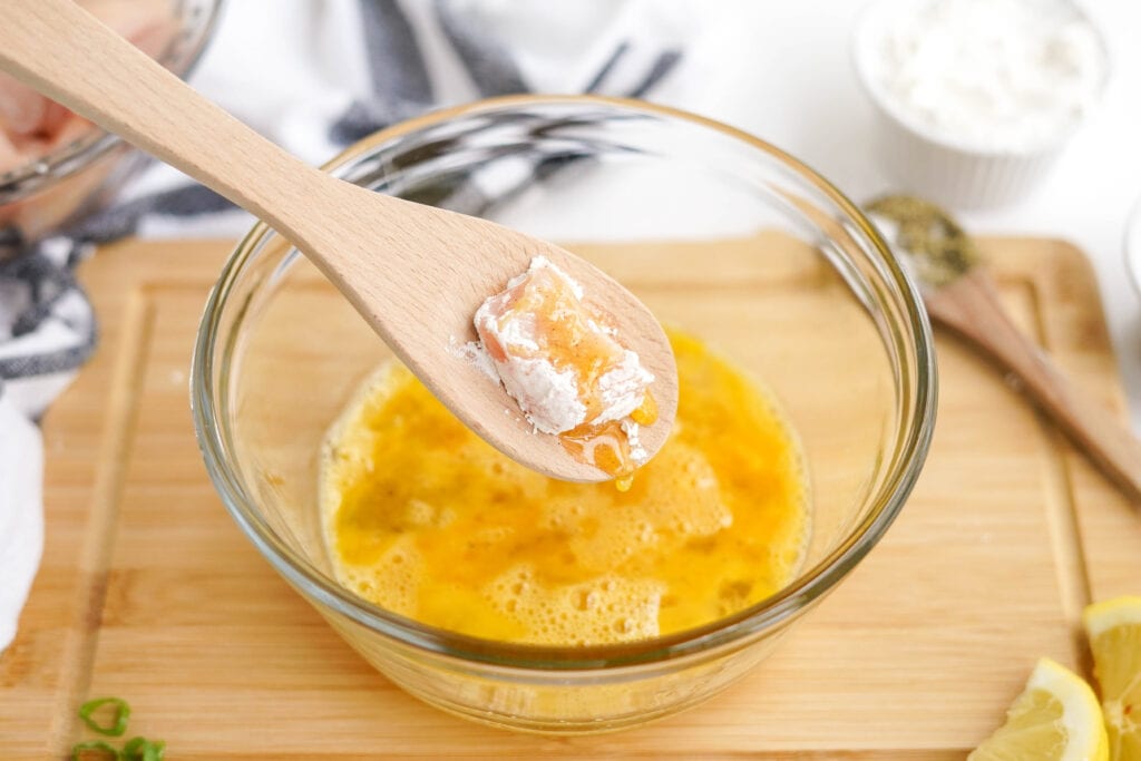 egg batter for crispy fried chicken in a bowl, wooden spoon