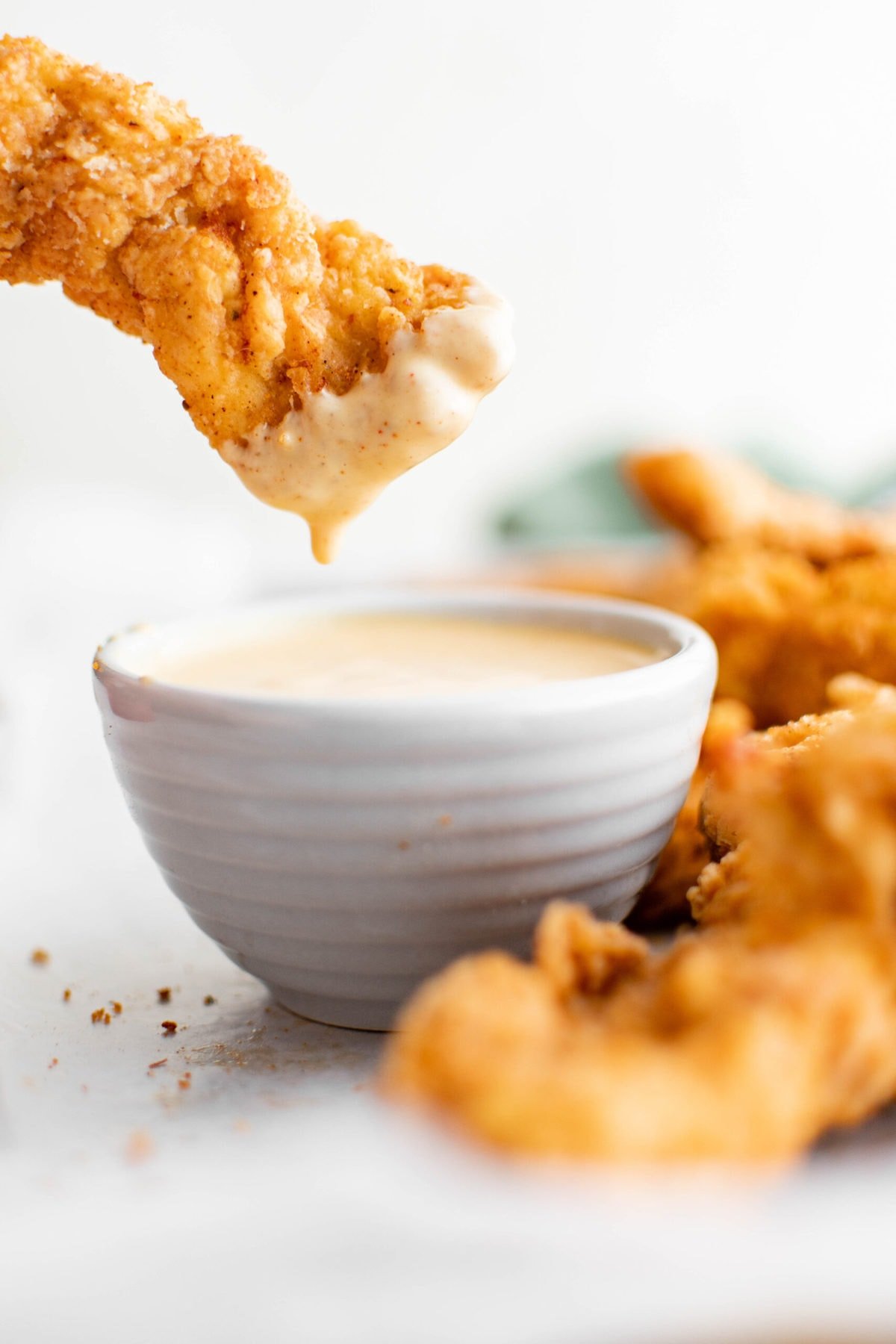 crispy chicken tenders, white dish, honey mustard dipping sauce.