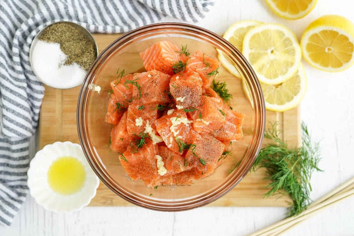 marinating chunks of salon in a bowl with garlic and dill