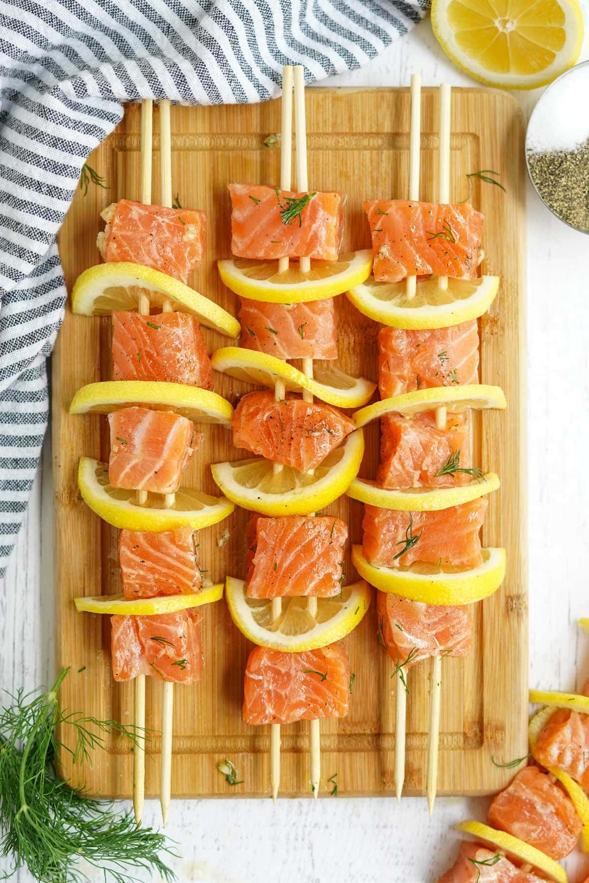 raw salmon threaded onto skeres with lemon slices and dill